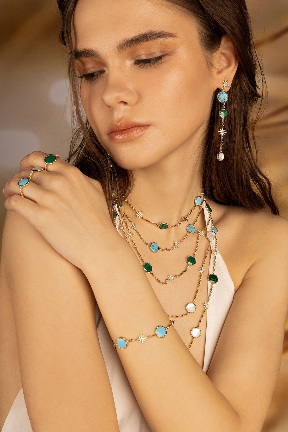 Necklaces APM Monaco; Earrings APM Monaco; Rings APM Monaco; Bracelets APM Monaco—yellow gold with blue, green, and white stones.