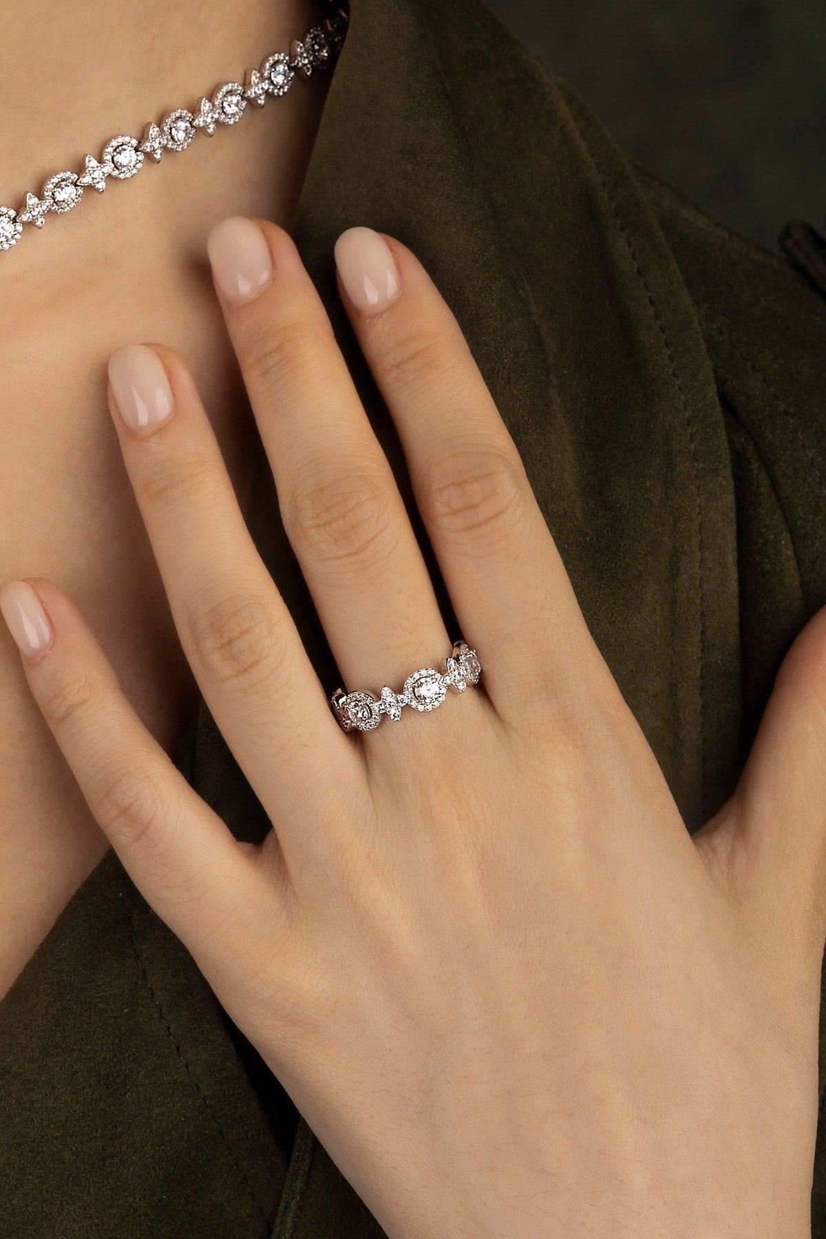 Close-up of a hand wearing a silver ring on a dark background