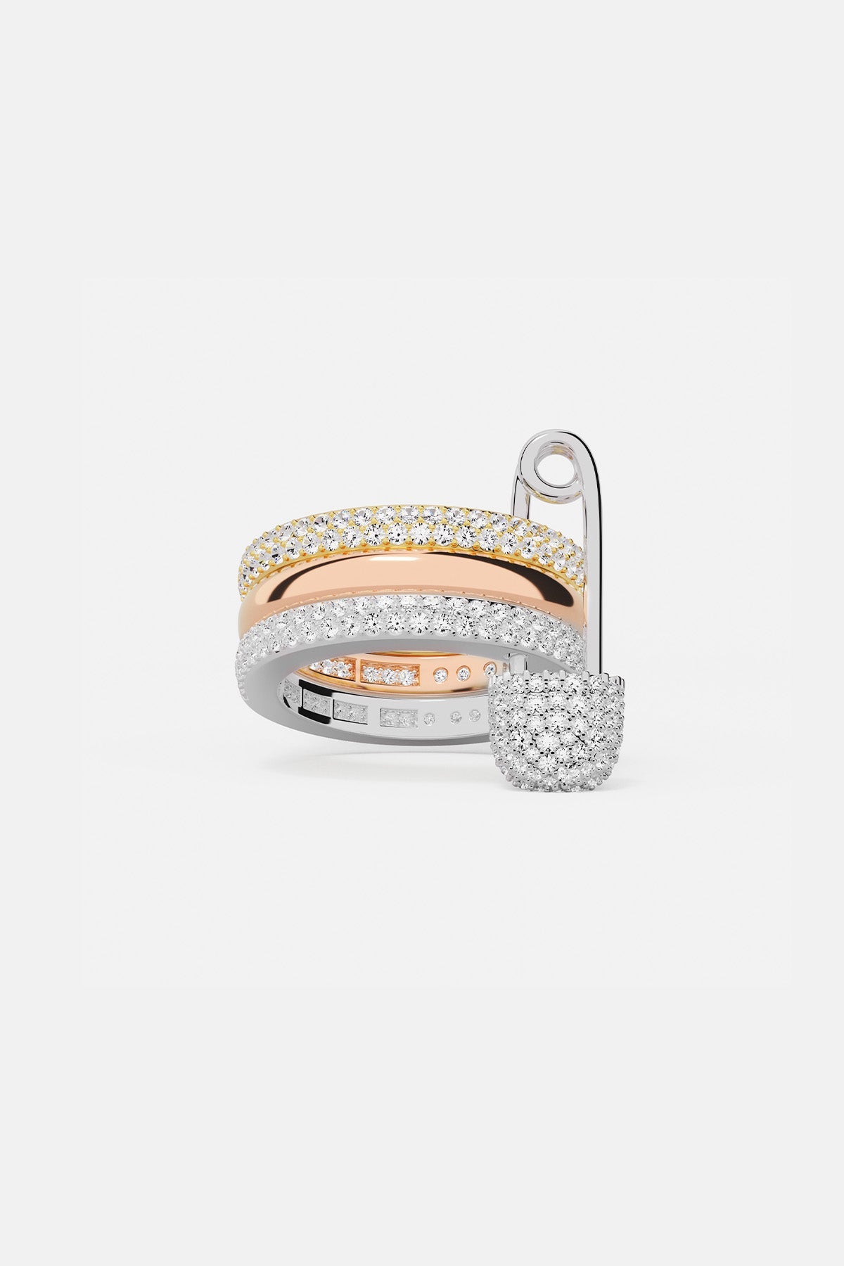 Rings APM Monaco fashion jewelry: a white, triple-hoop safety-pin ring with pavé diamonds, paired with two additional diamond rings.