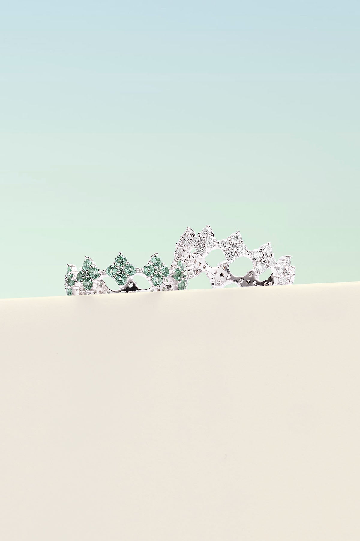 Rings APM Monaco, two pavé spark rings featuring green and clear stones.