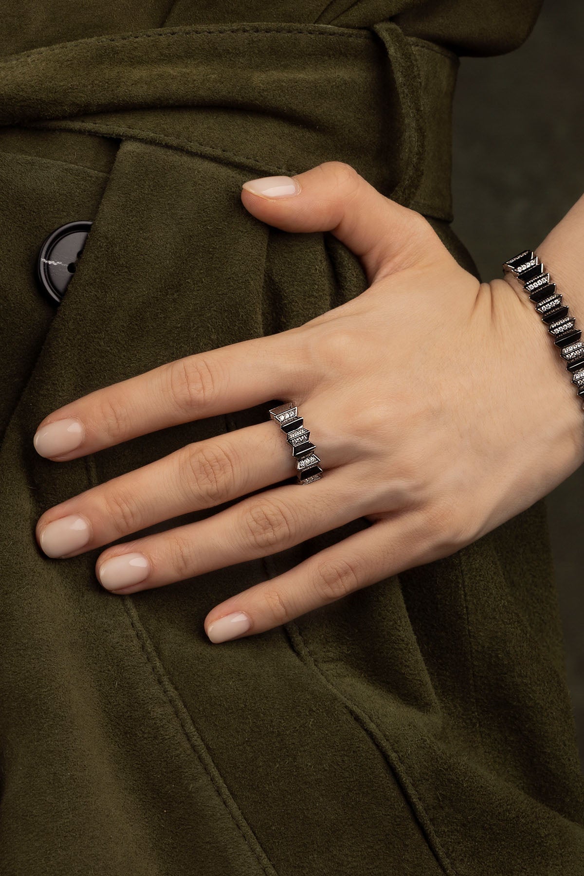 Hand wearing a ring on a dark background