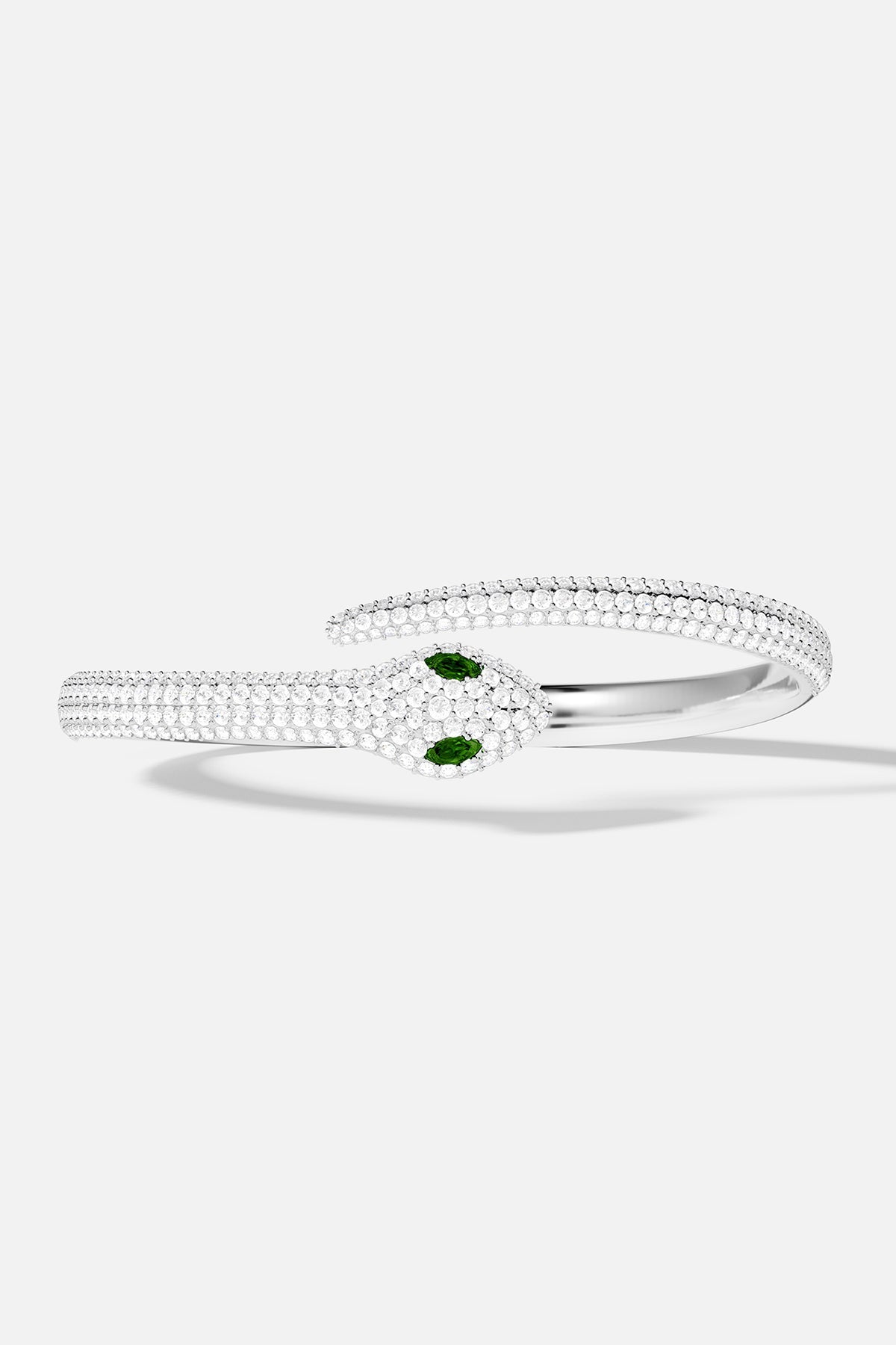 Bracelets APM Monaco, snake wrap cuff in silver-tone metal with white pavé rhinestones and green eyes.