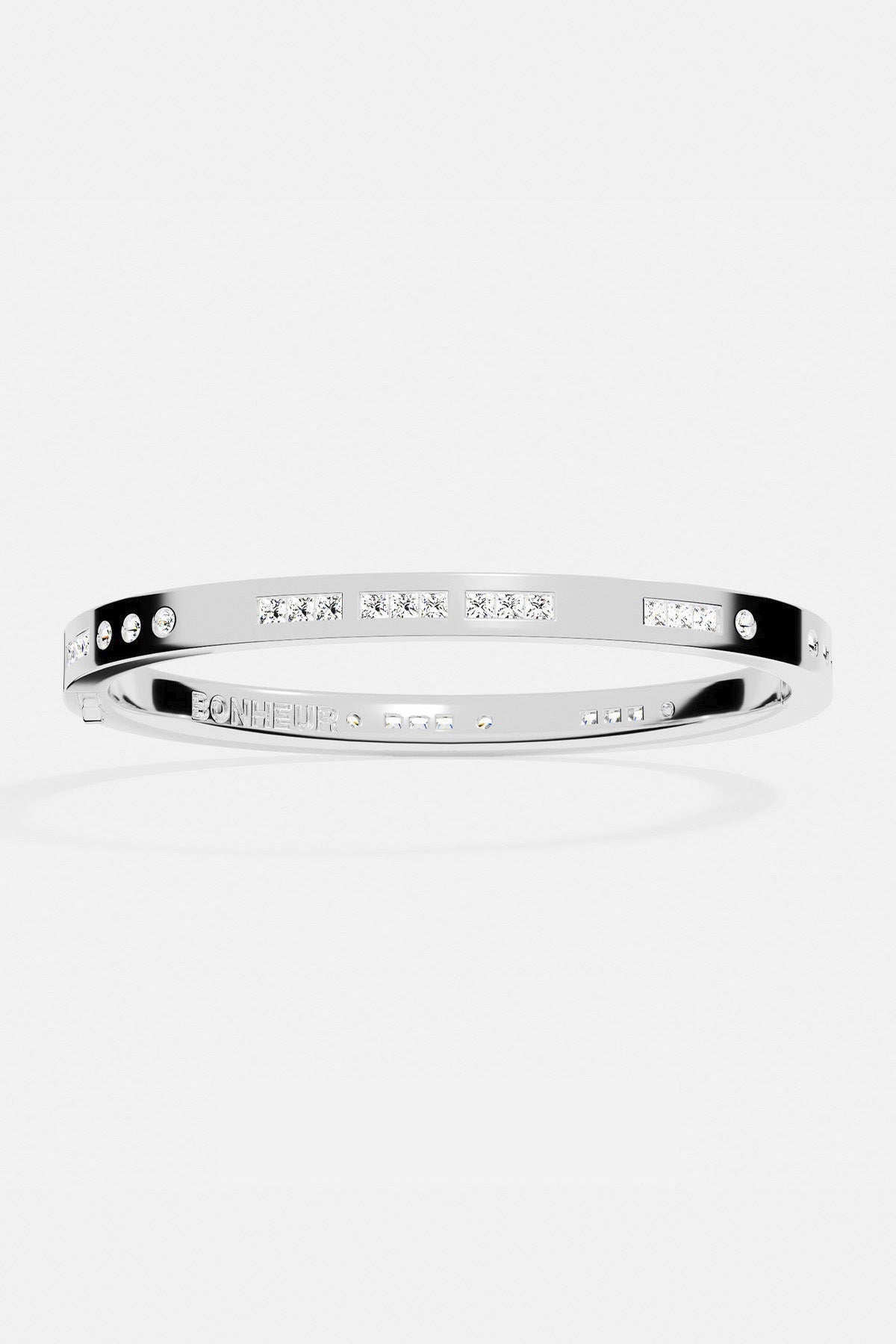 Bracelets APM Monaco, white-silver morse-code bangle with pavé stones along a delicate line.