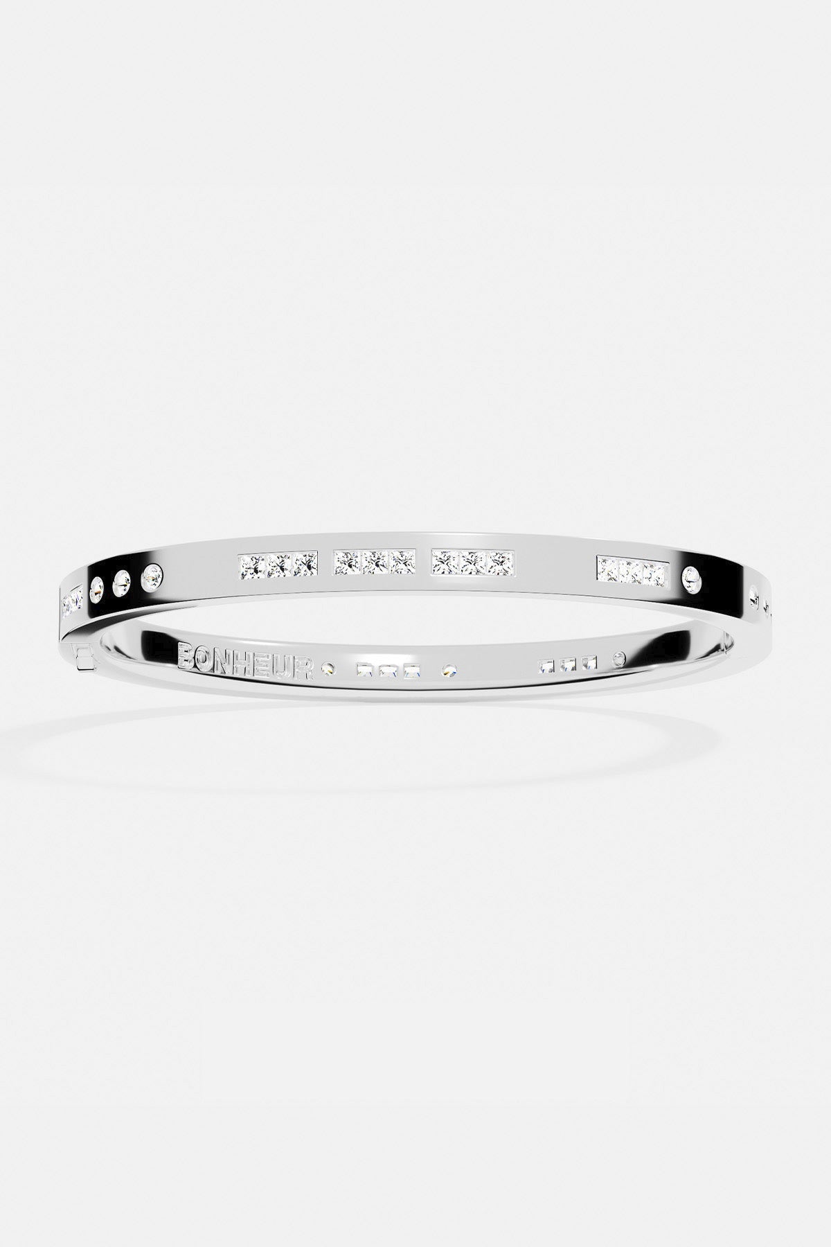 Bracelets APM Monaco, white-silver morse-code bangle with pavé stones along a delicate line.