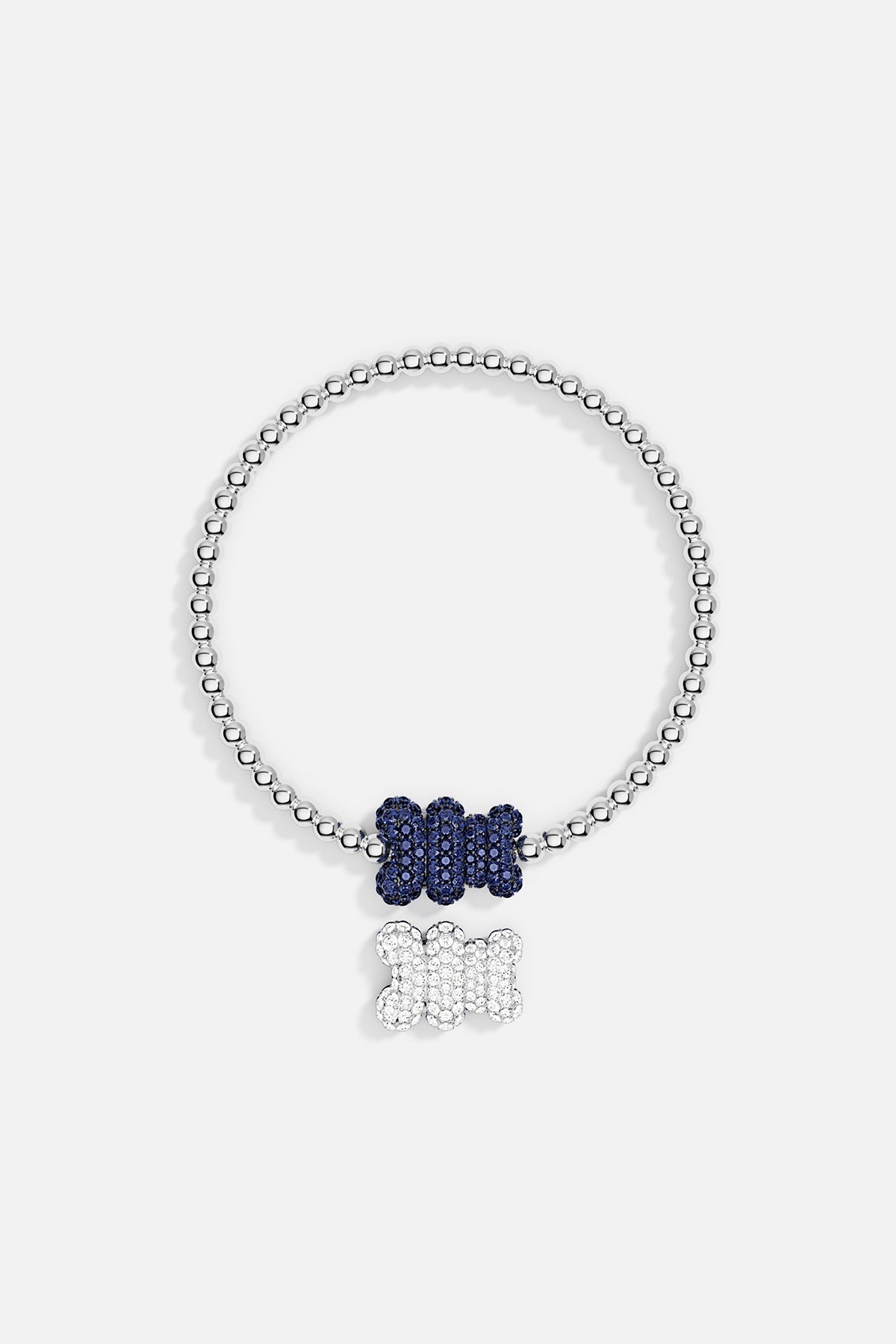 Bracelets APM Monaco: stretch beaded bracelet in silver-tone beads with two bone-shaped pendants, a blue pendant on the chain and a white pendant that dangles.