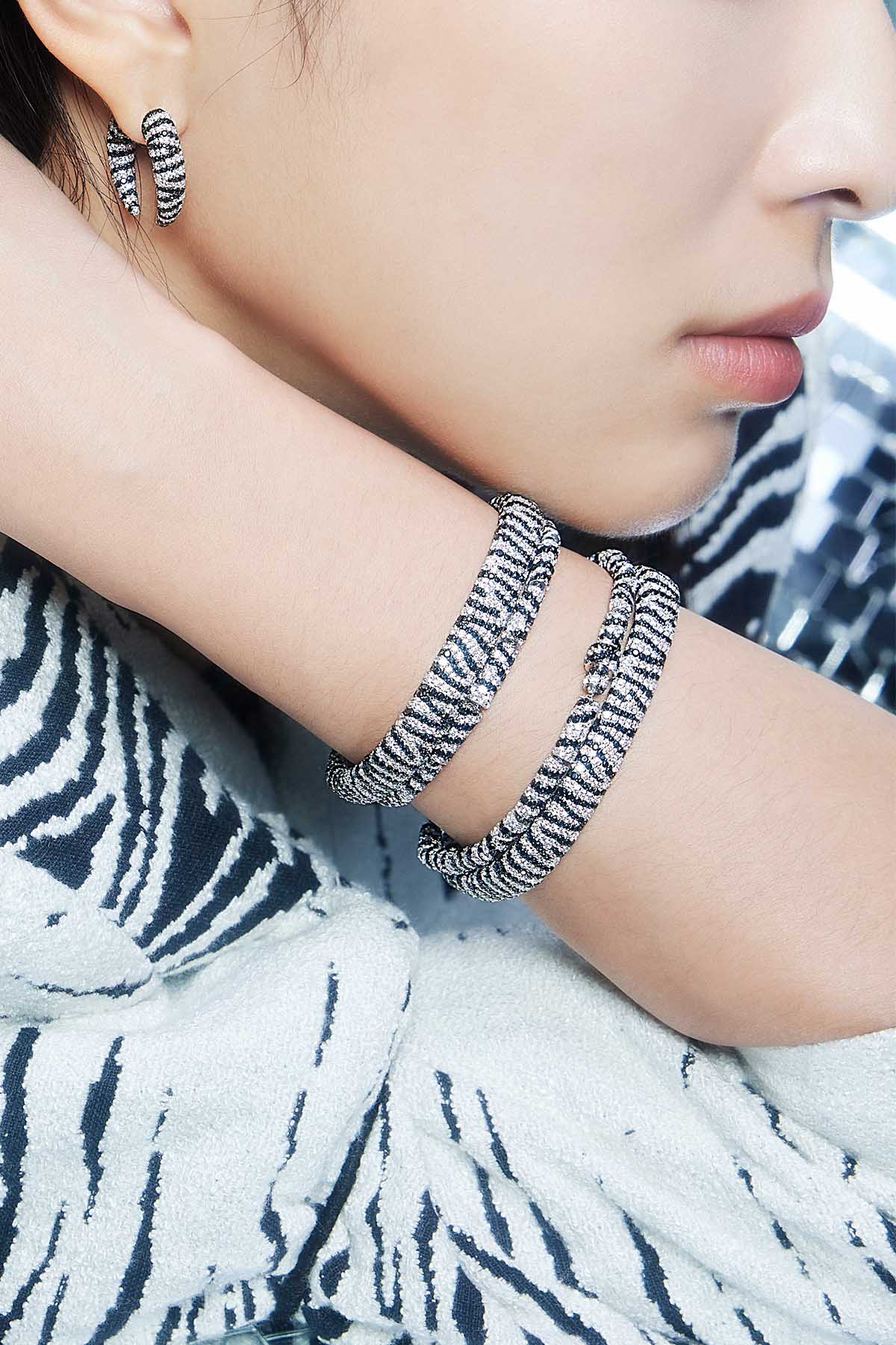 Bracelets APM Monaco: white bangles with black zebra stripes; Earrings APM Monaco: matching hoop earrings.