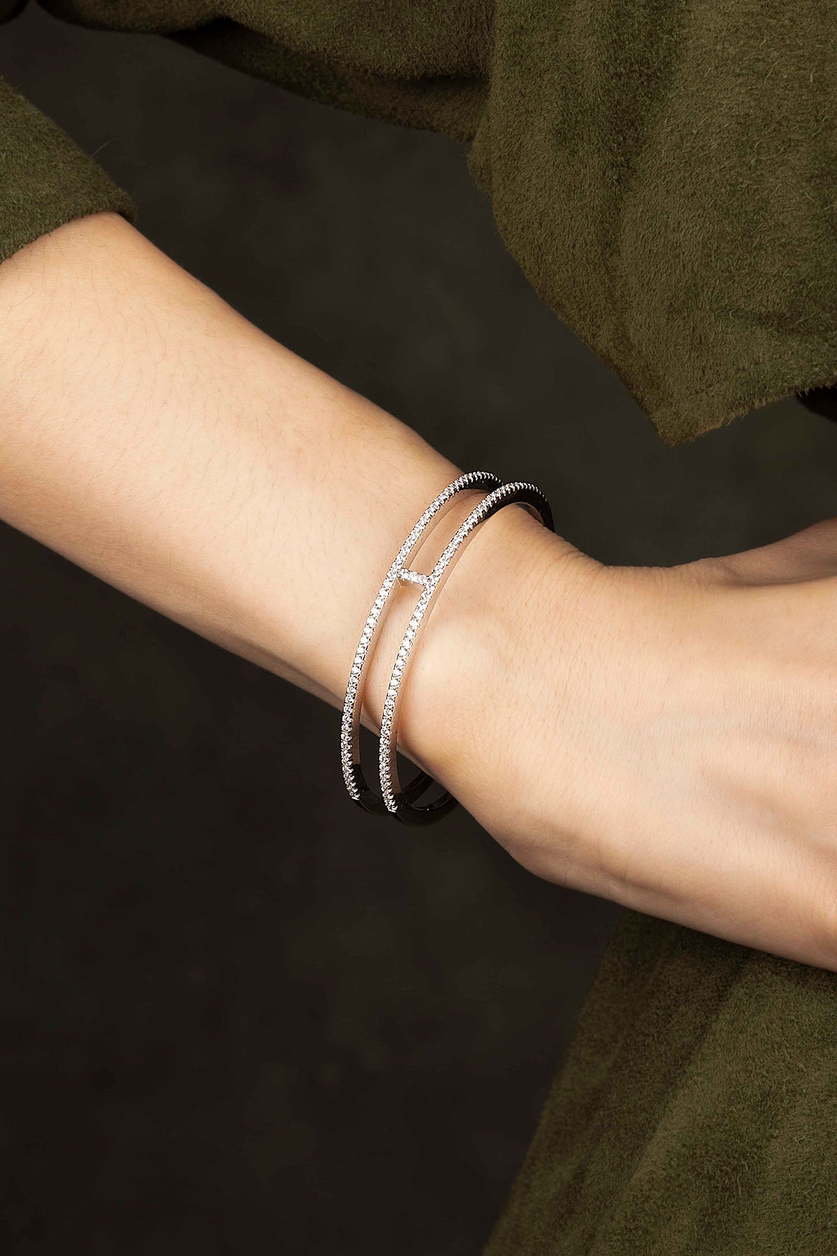Silver bracelet on a wrist against a dark background