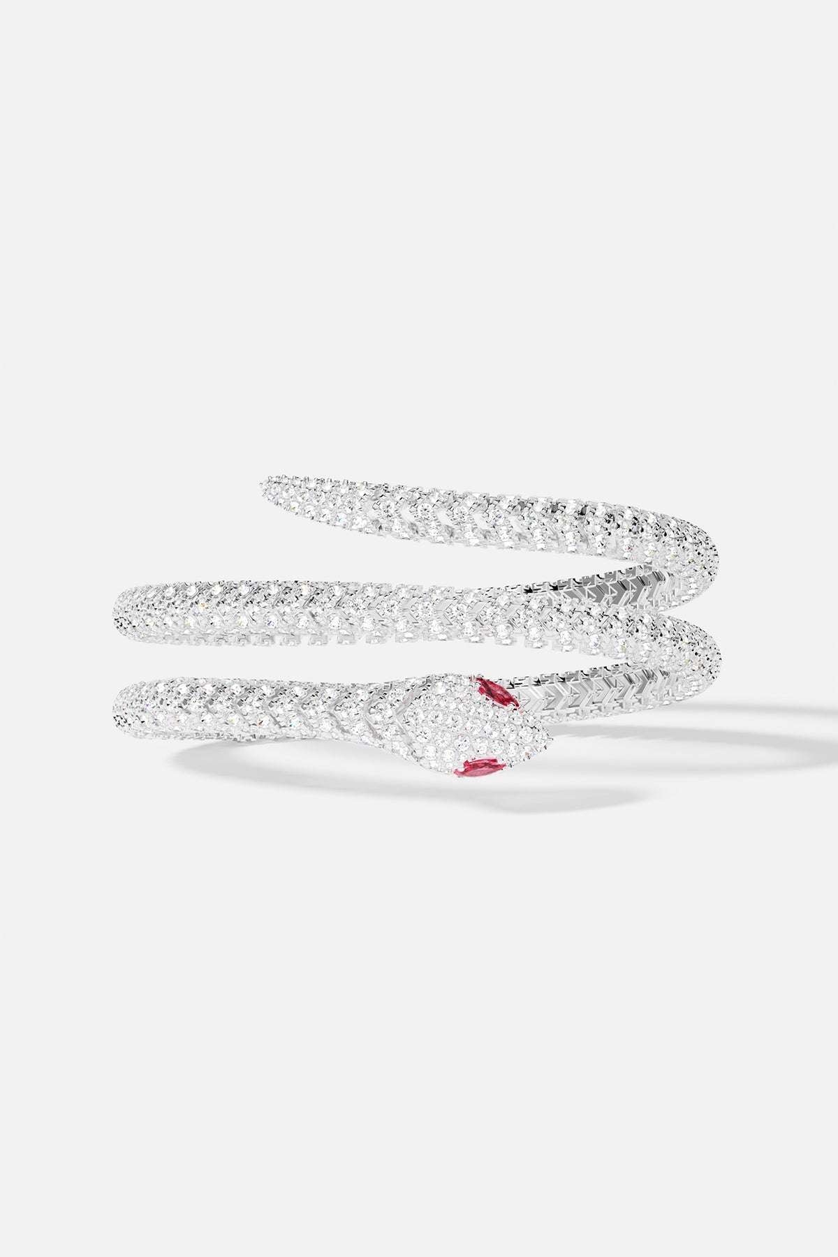 Bracelets APM Monaco: snake-shaped, double wrap-around bangle with pavé white stones and ruby-red eyes.