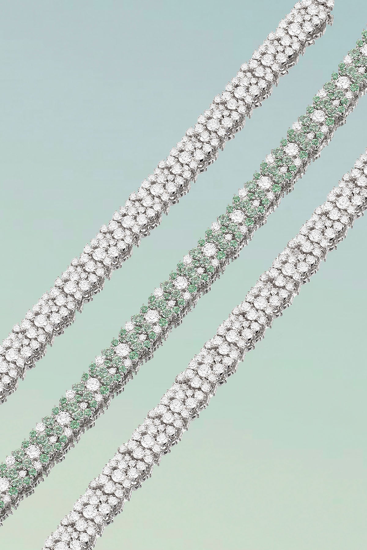 Bracelets APM Monaco - three white-metal drop bracelets with pave diamonds, laid diagonally.