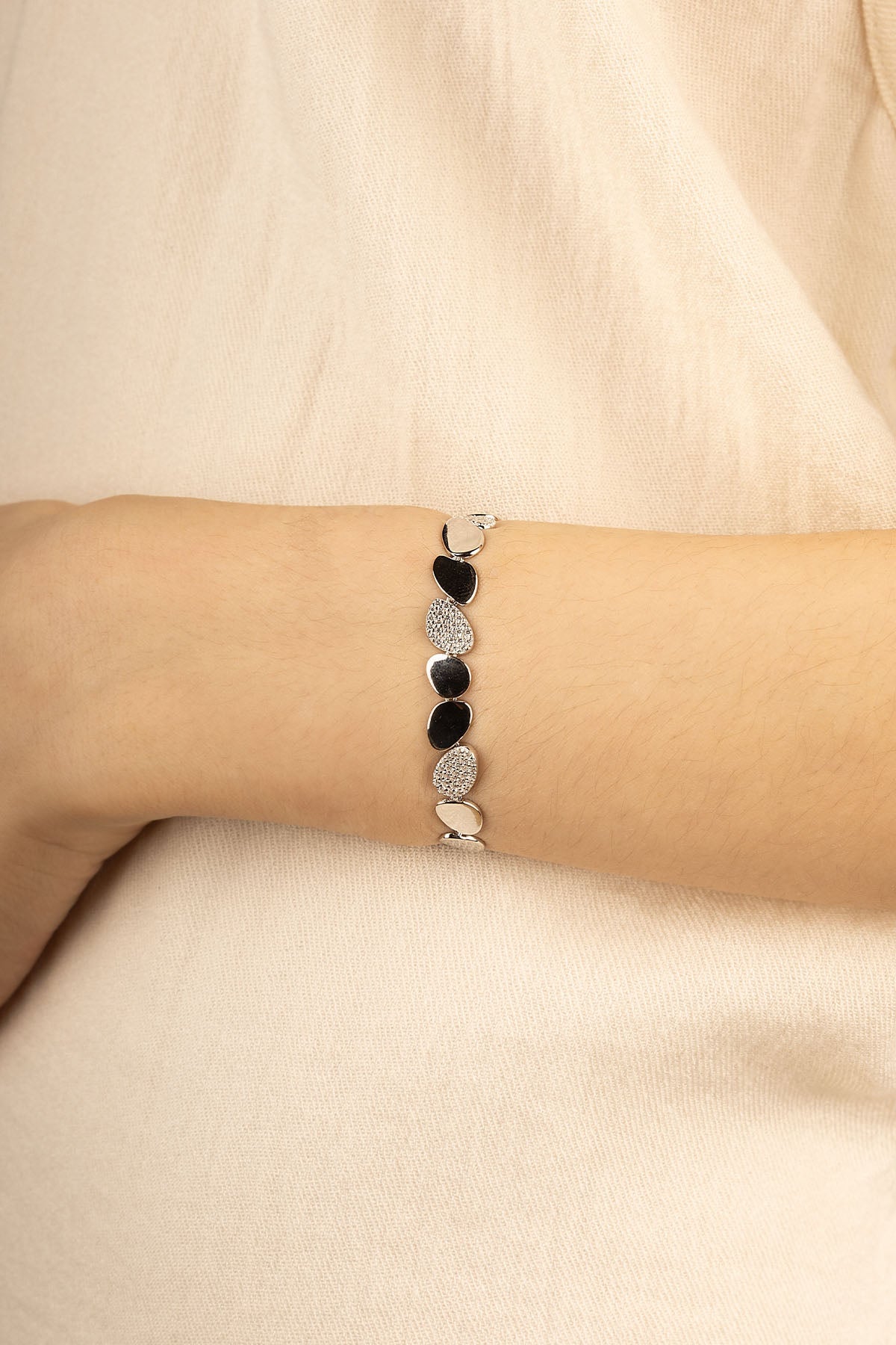 Bracelets APM Monaco silver-tone galet bracelet with alternating black stones and pavé diamonds.