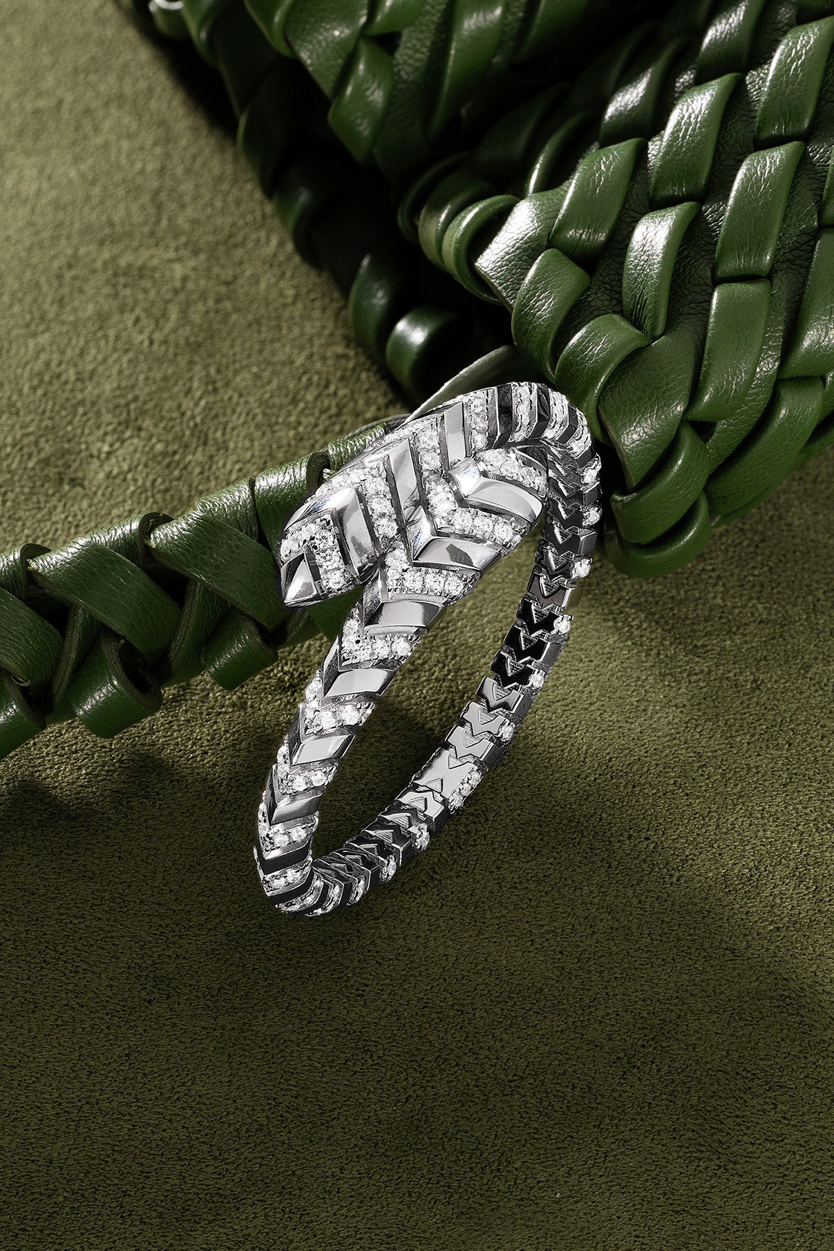 Silver bracelet on a green leather background