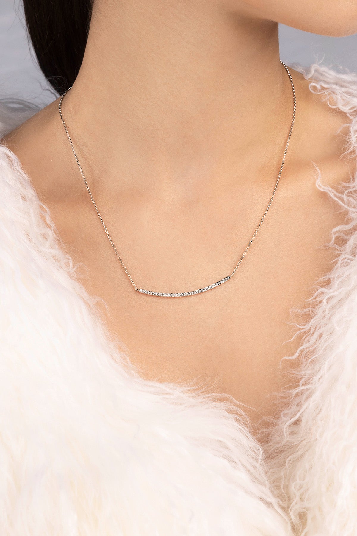 APM MONACO adjustable silver necklace with paved arched pendant worn by a model