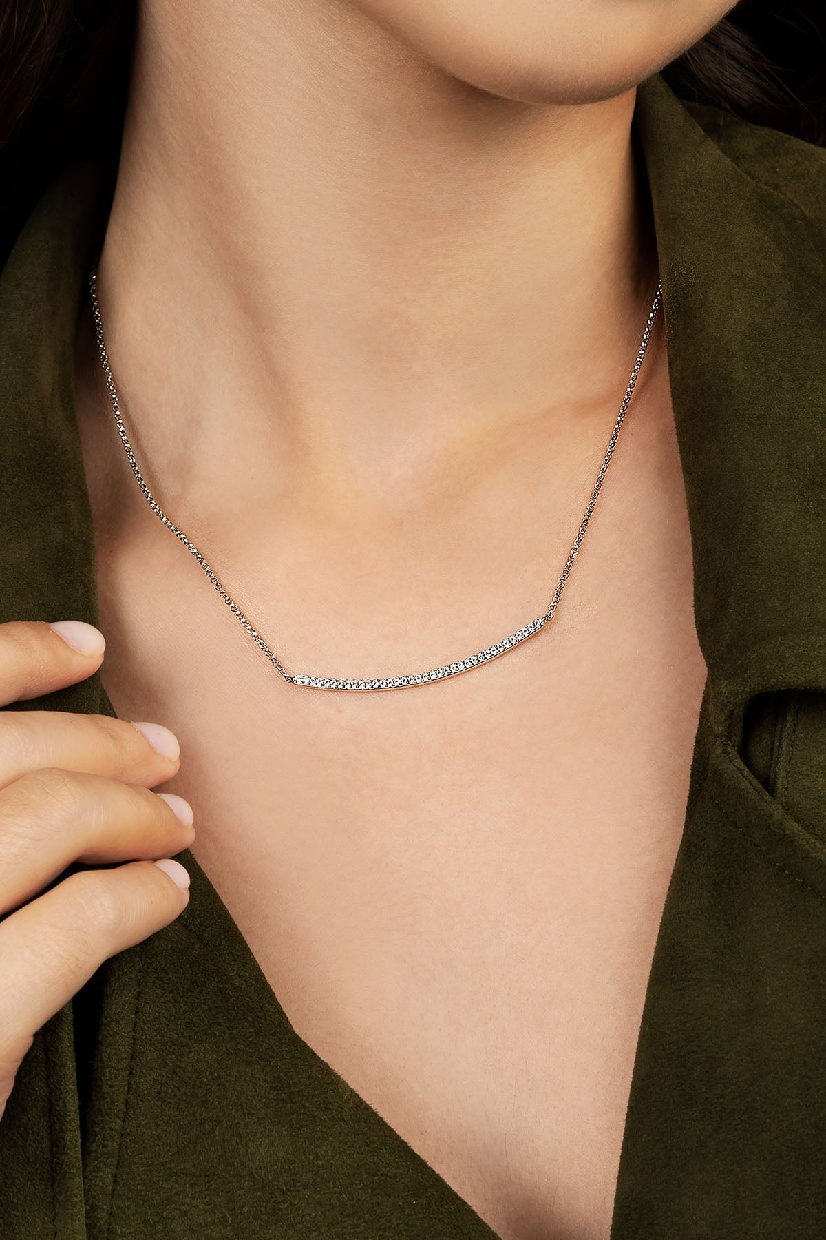 Silver necklace on a person wearing a green shirt