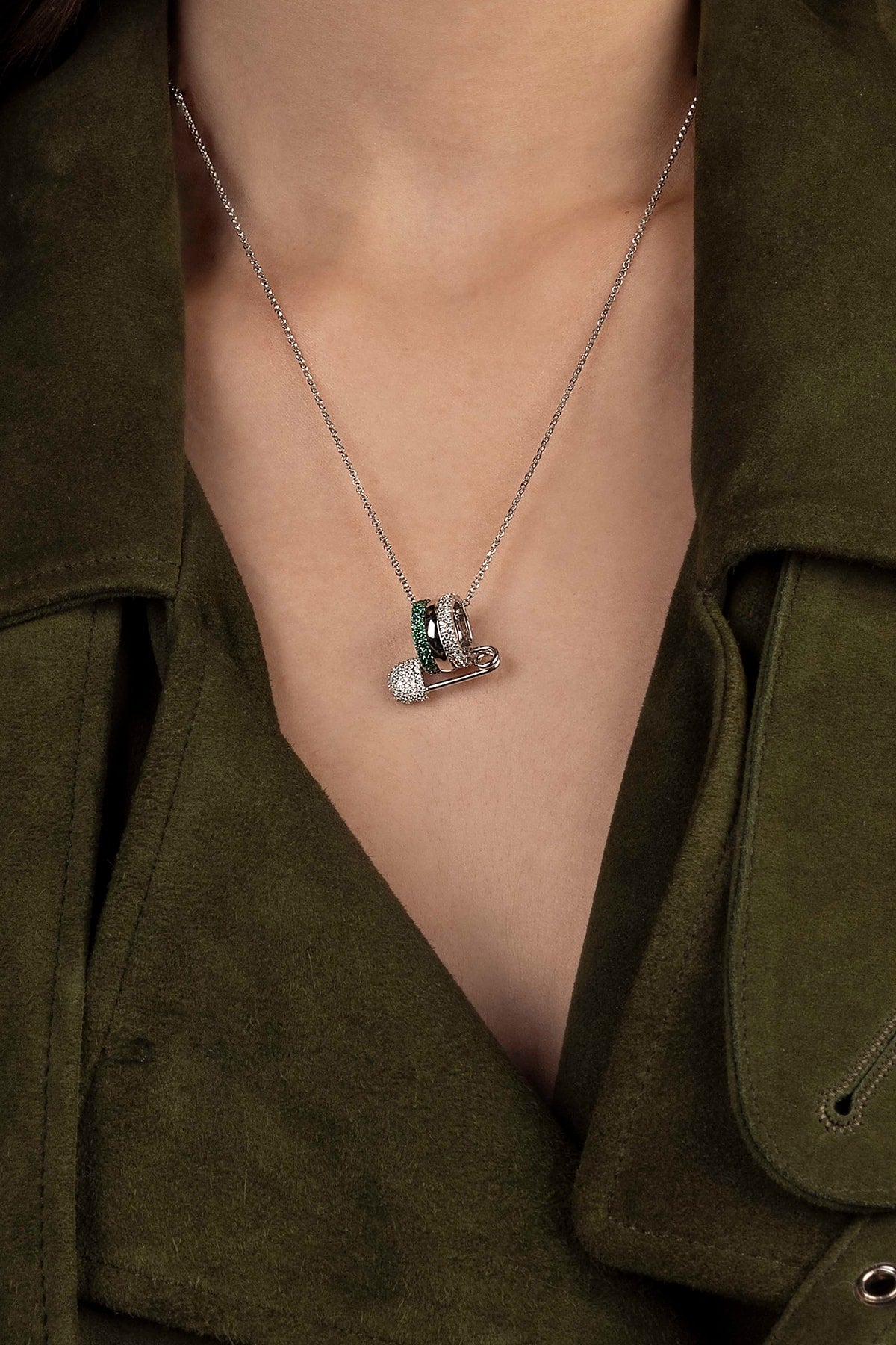 Necklace with a pendant worn by a model in an olive green outfit