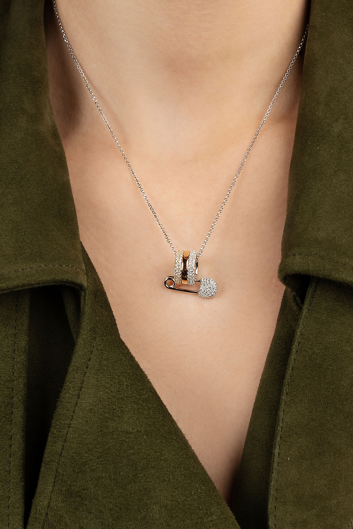 Necklace with a pendant worn by a person wearing a green jacket.