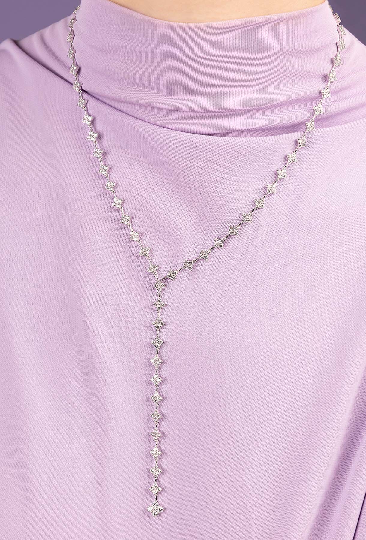 Silver necklace with clear stones on a light purple turtleneck