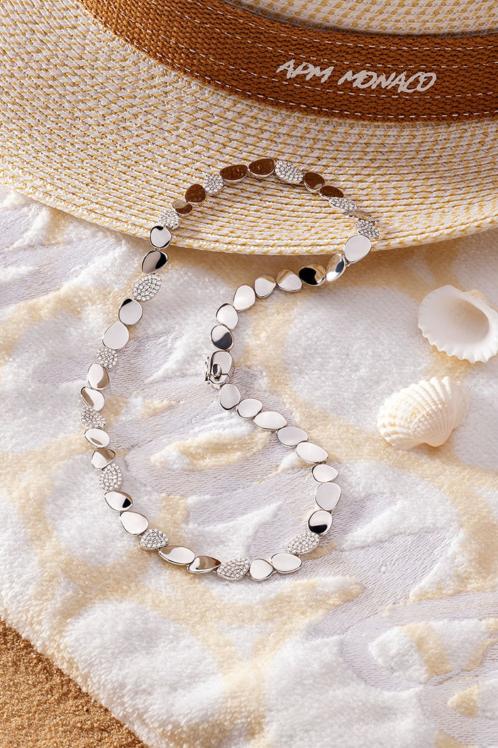 Necklaces APM Monaco, gold-tone galet choker with pebble motif and pavé accents.