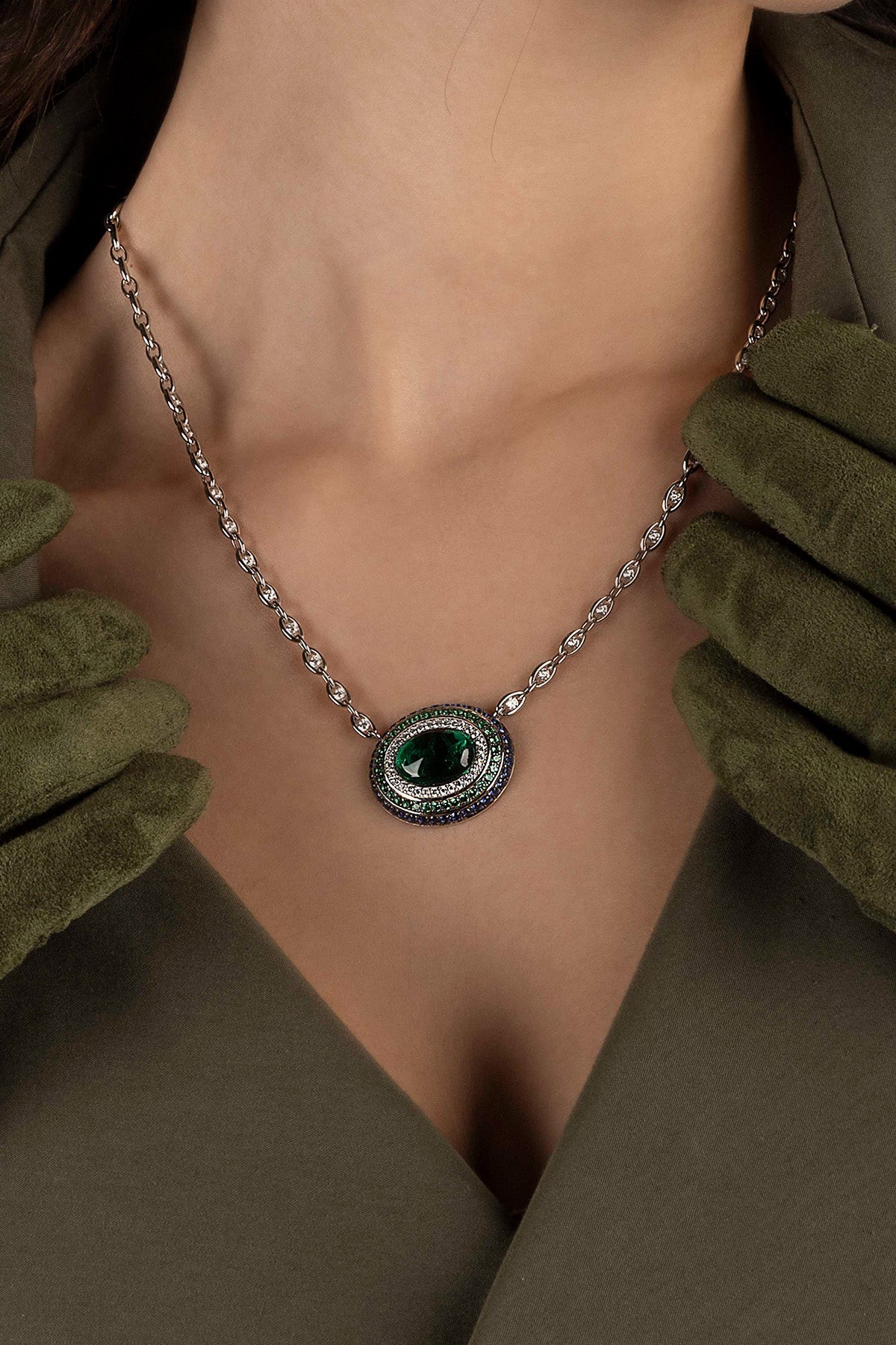 Necklace with a green stone worn by a model in a green outfit.