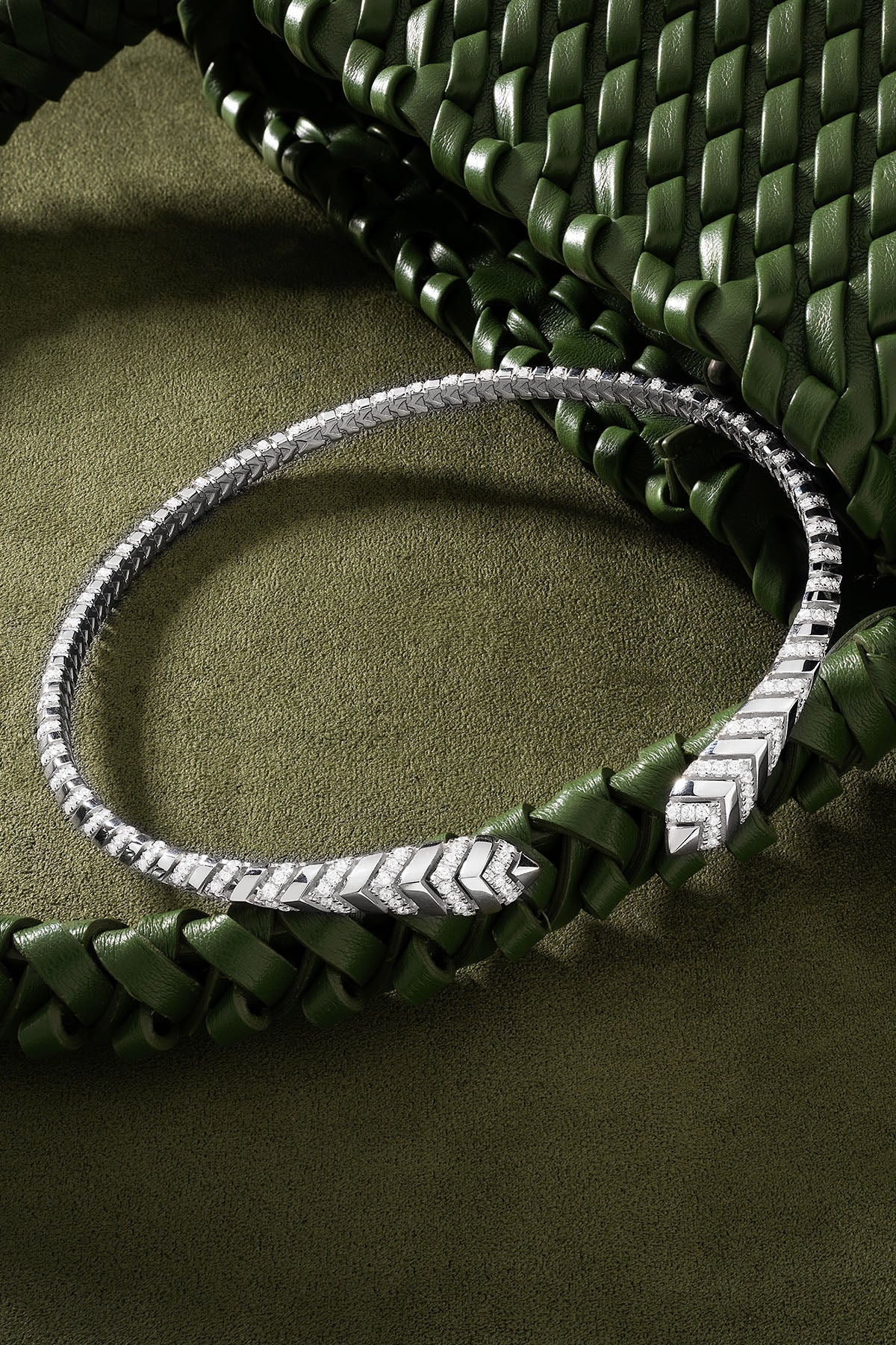 Silver choker on a braided green leather strap.