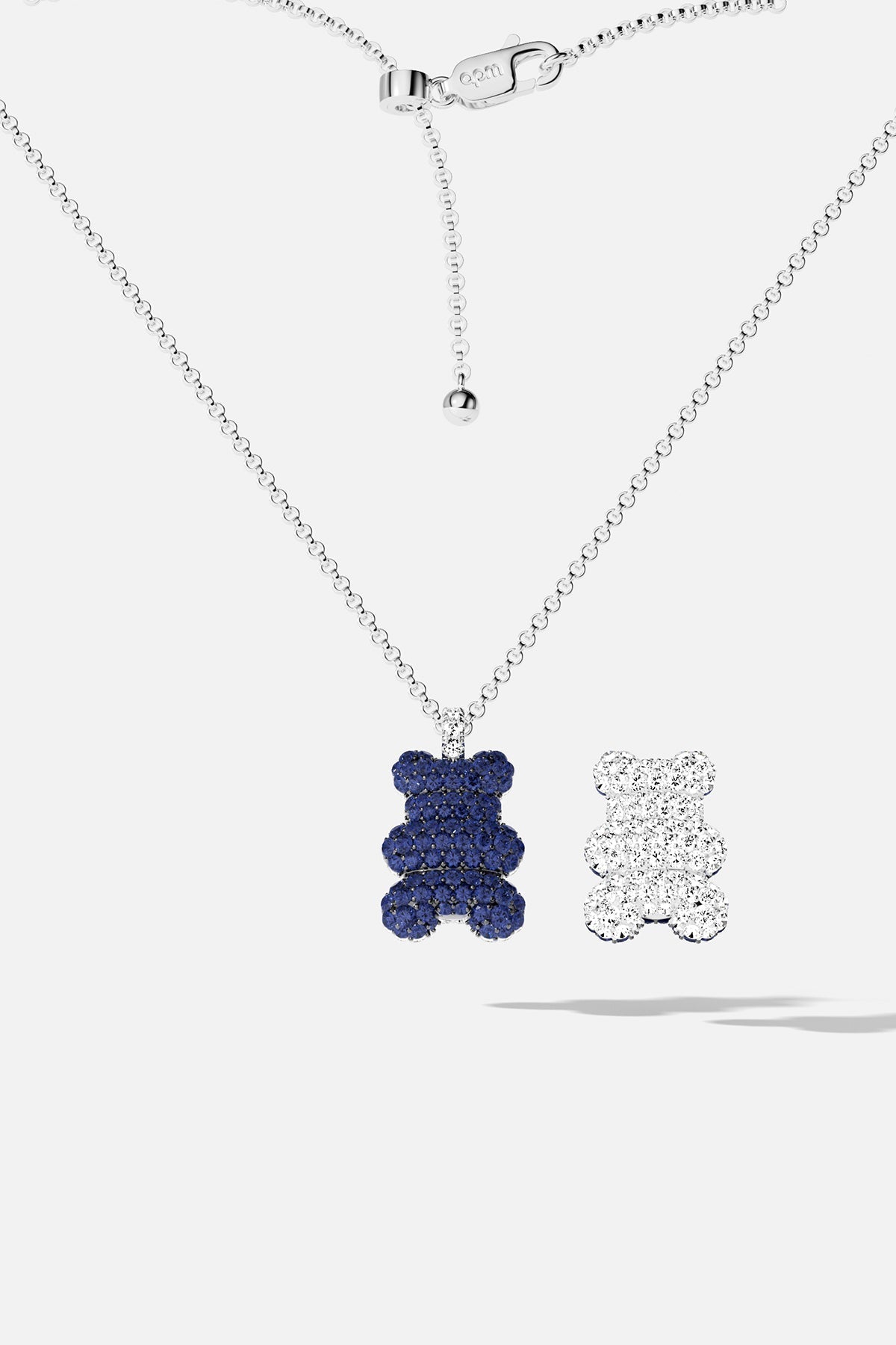 Necklaces APM Monaco: silver chain with blue bear pendant beside a white bear pendant.