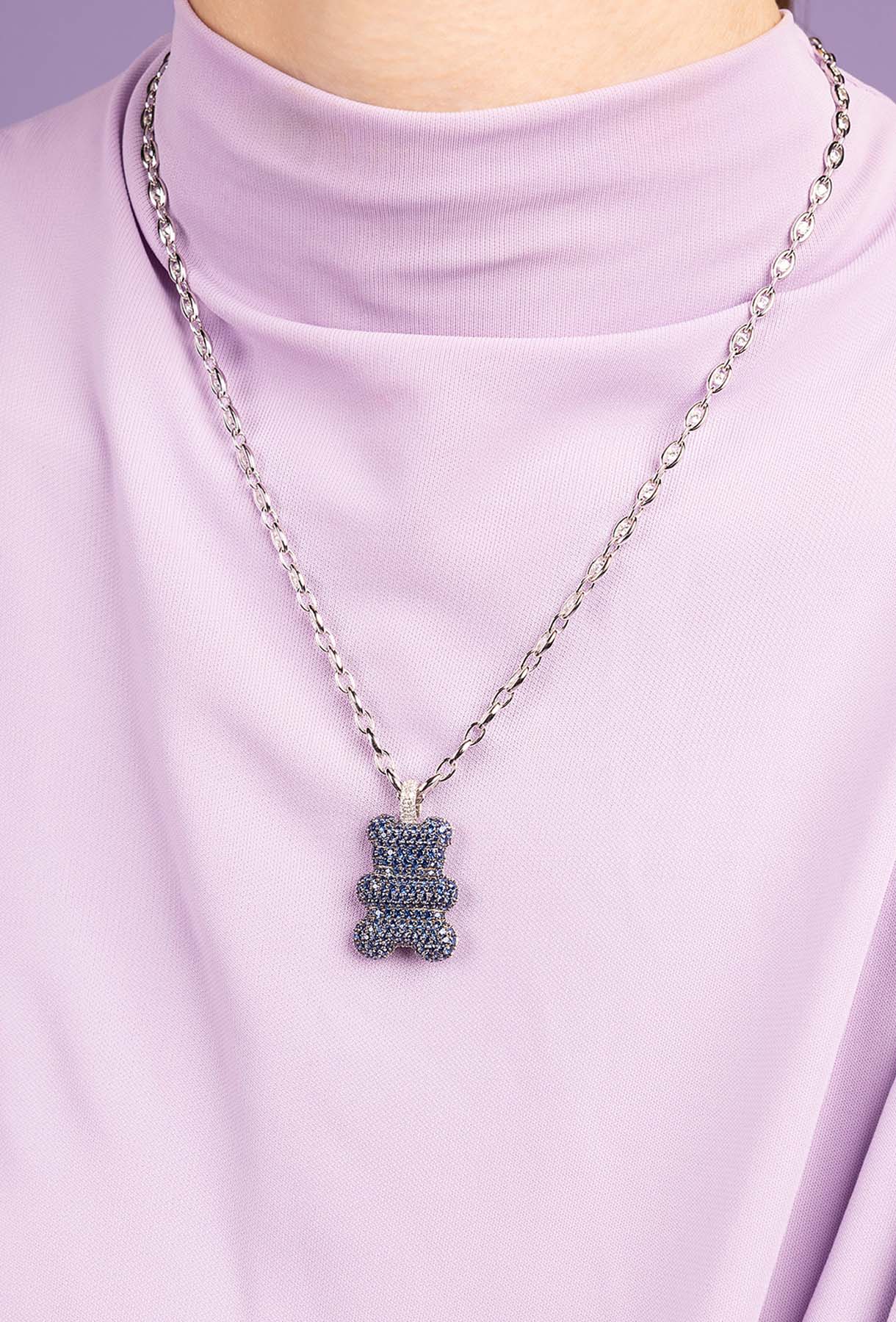 Necklace with a bear-shaped pendant on a person wearing a light purple turtleneck.