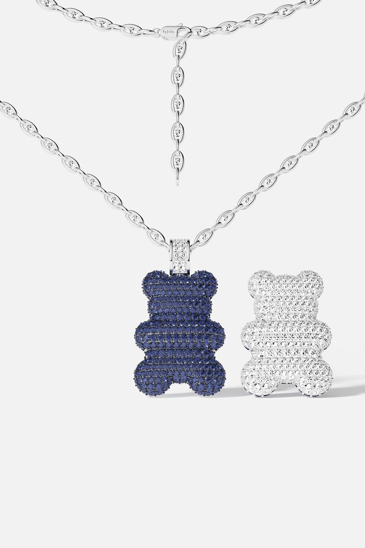 A bear-shaped pendant, with different color on both side: blue and silver, on a white background.