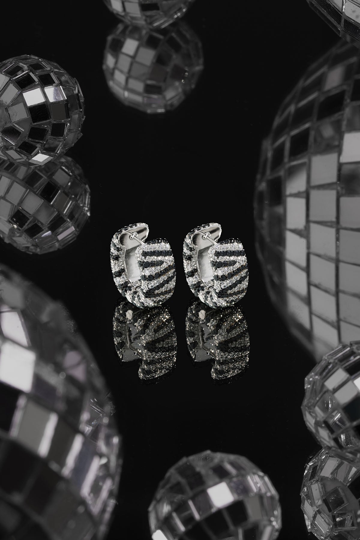 Earrings APM Monaco – zebra hoop earrings with pavé crystals, black and white striped hoops, circular design.
