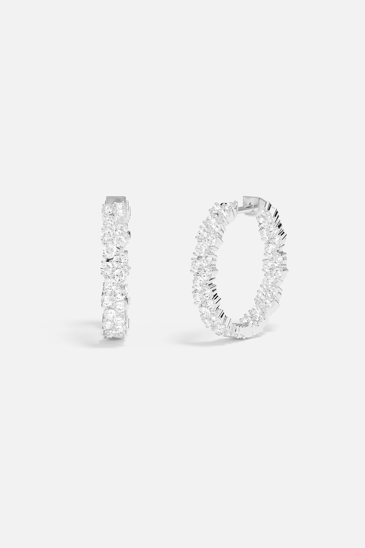 Earrings APM Monaco white pavé hoop earrings with clear stones.