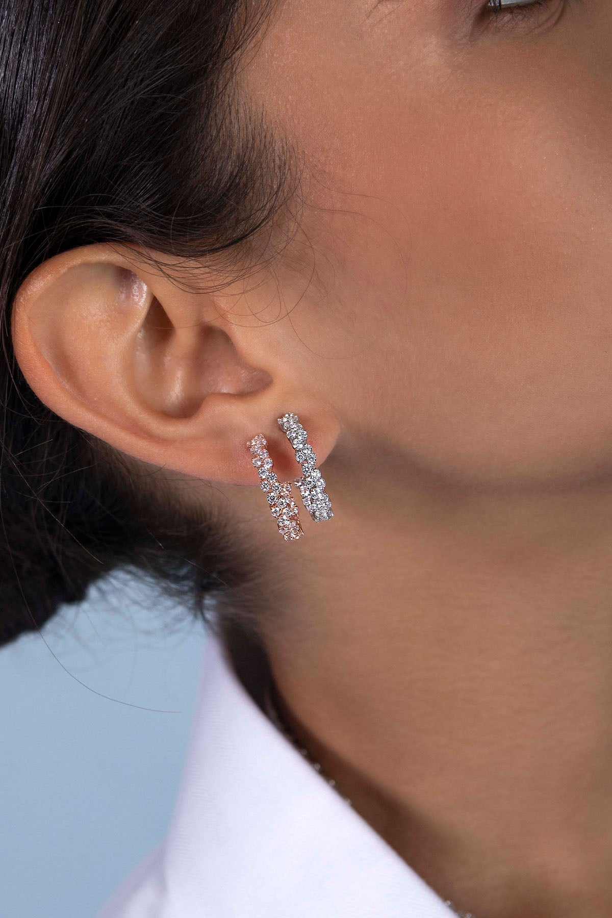 Earrings APM Monaco pavé hoop earrings with white diamonds, two diamond-encrusted hoops on the ear.