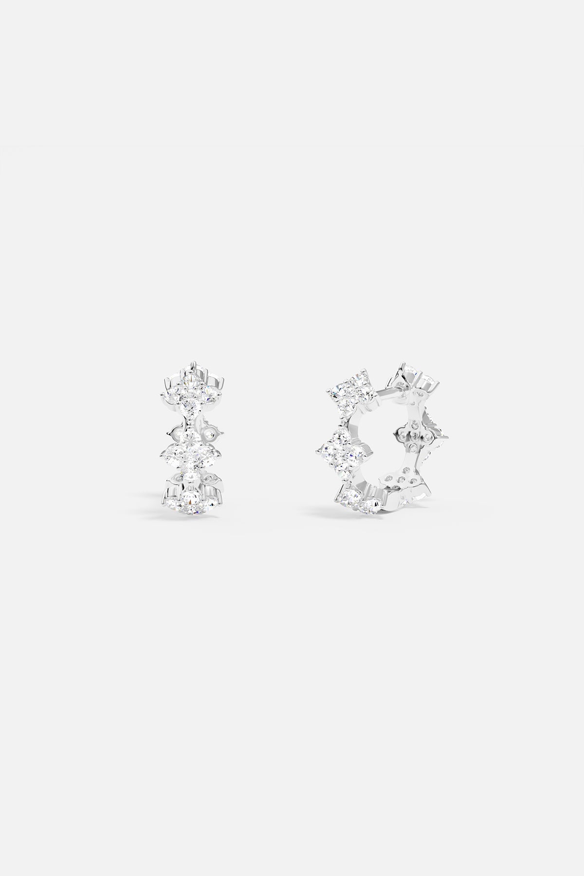 Earrings APM Monaco. Pair of white-silver huggie hoops with diamond-shaped white pavé stones.