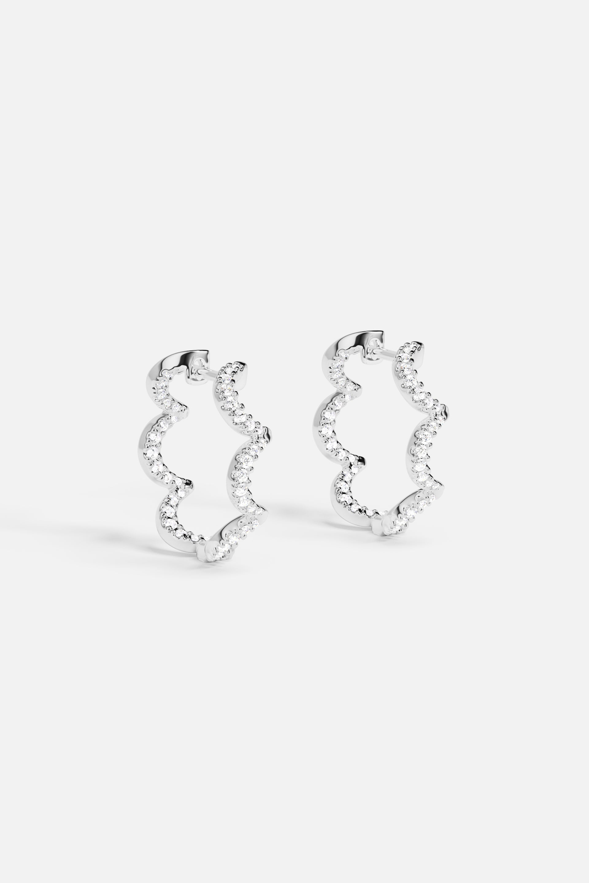 Earrings APM Monaco, silver wavy hoop with white stones.