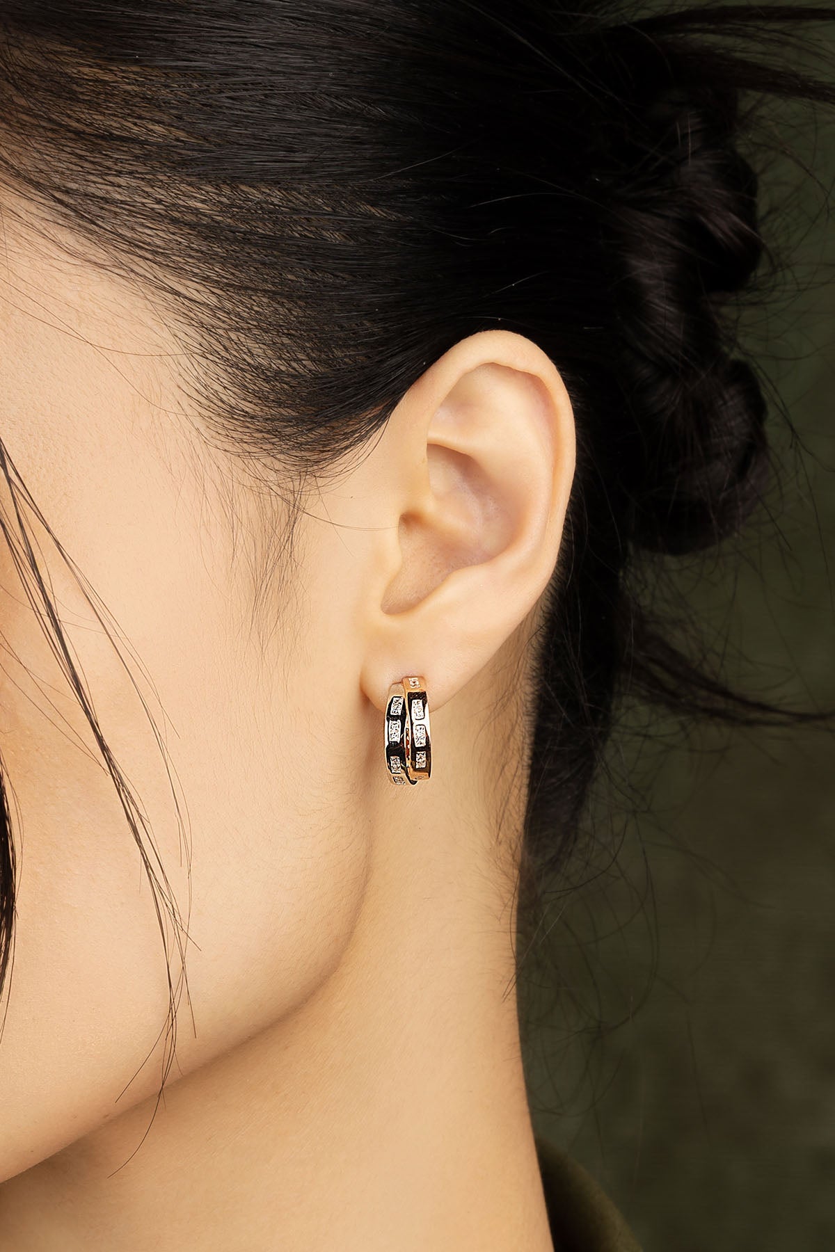 Close-up of an ear wearing a hoop earring with a blurred background