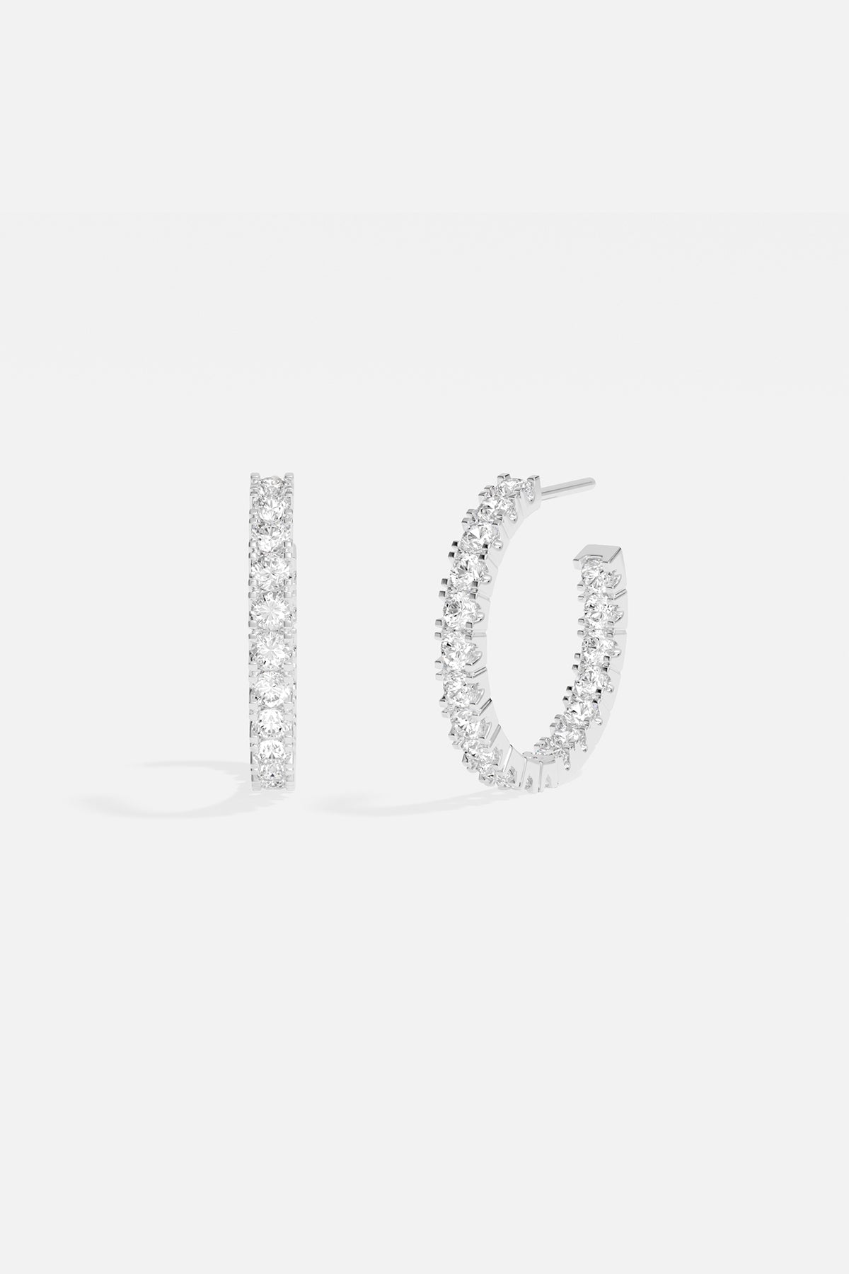 Earrings APM Monaco pavé hoop earrings in white silver-tone metal with clear pavé stones.