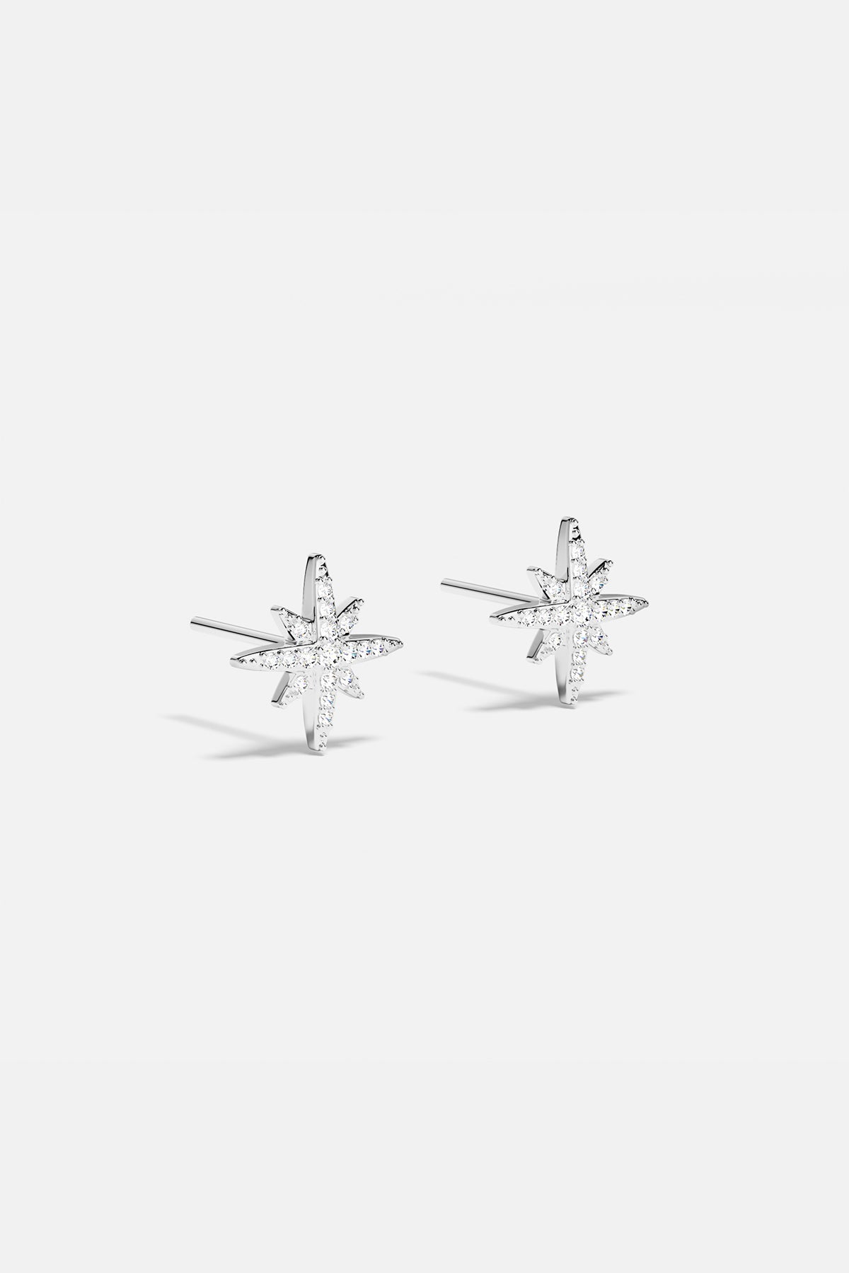 Earrings APM Monaco: silver starburst stud earrings with white stones.