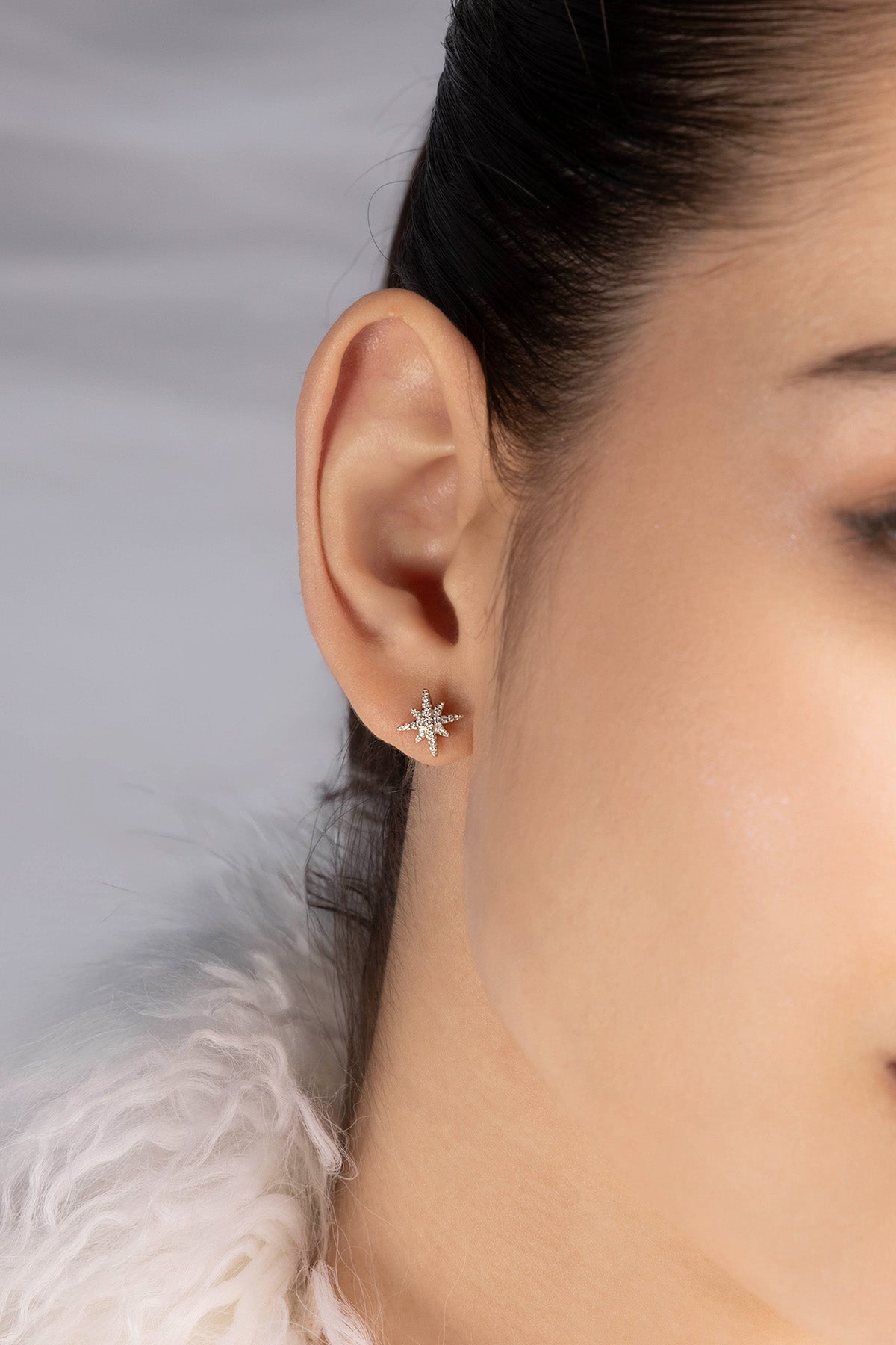 Close-up of an ear wearing a earring with a soft background