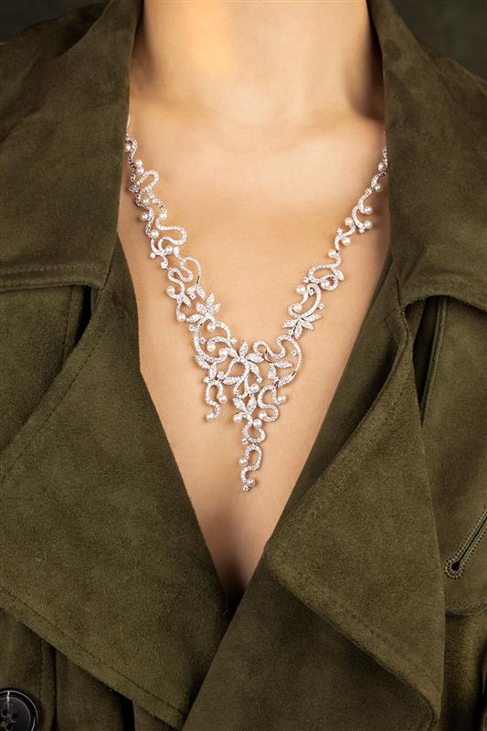 Person wearing APM MONACO statement adjustable flower silver necklace with a green jacket