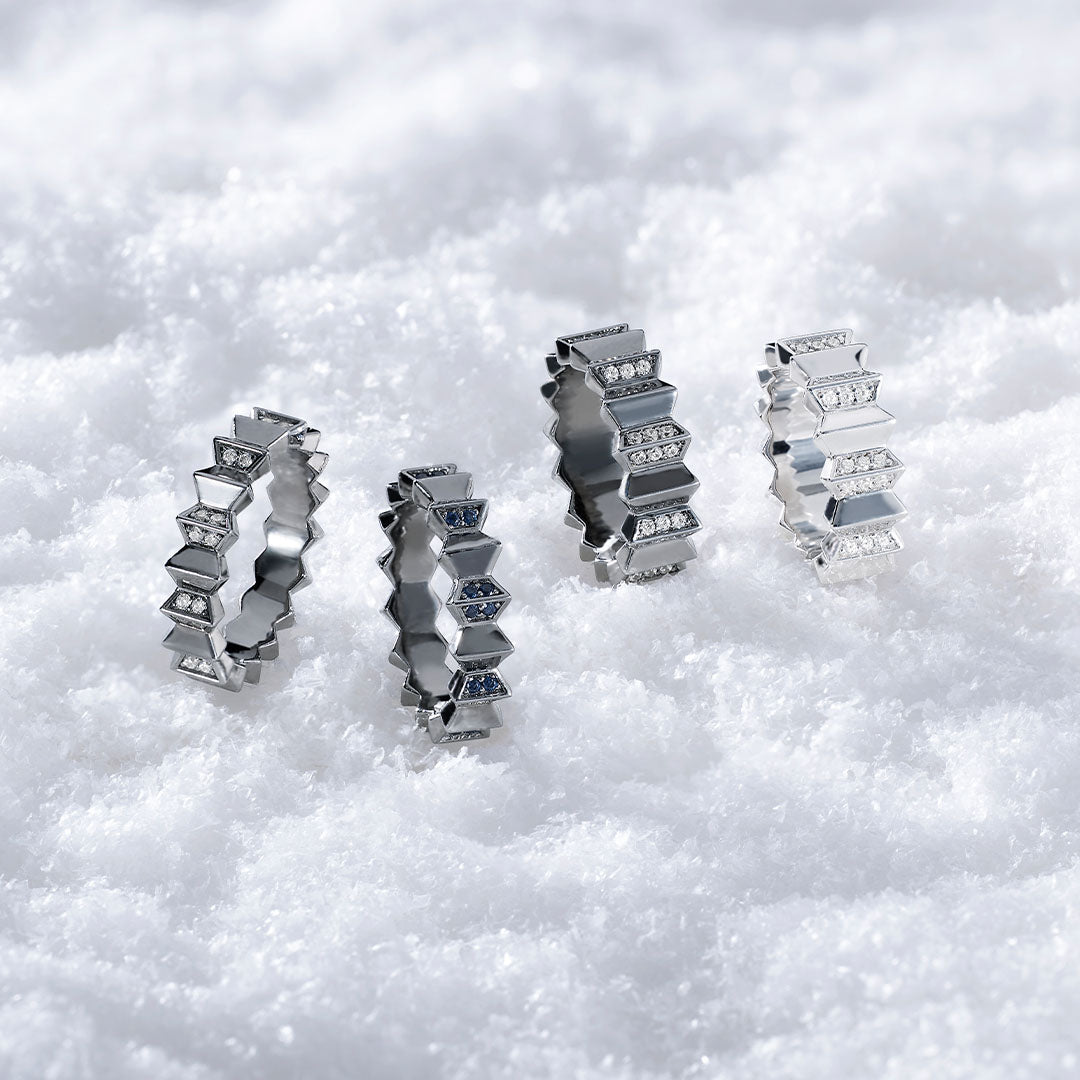 Four APM MONACO silver ring from up and down collection on a white snowy background