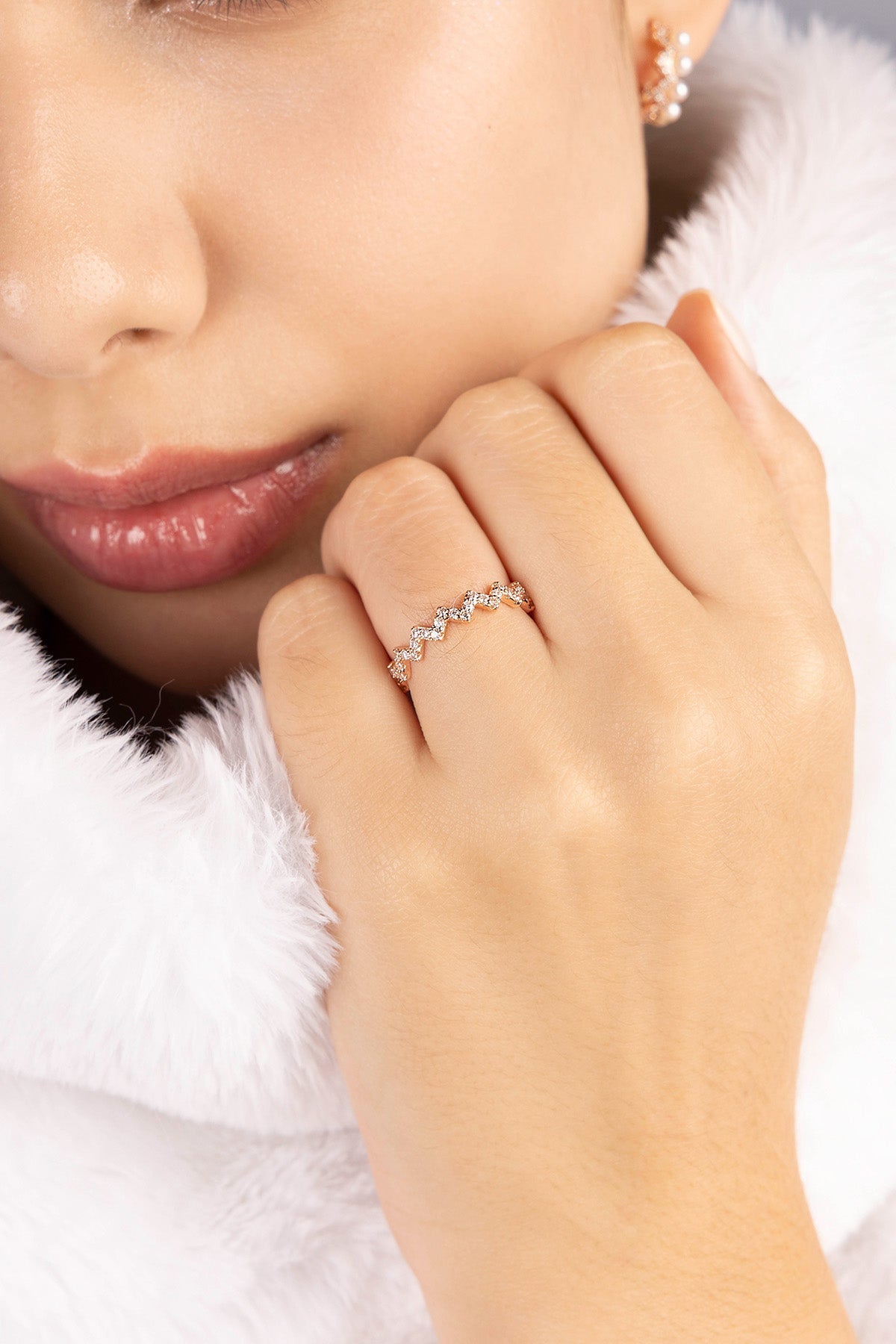 Close-up of a hand wearing a zirconia stones ring with a soft focus background
