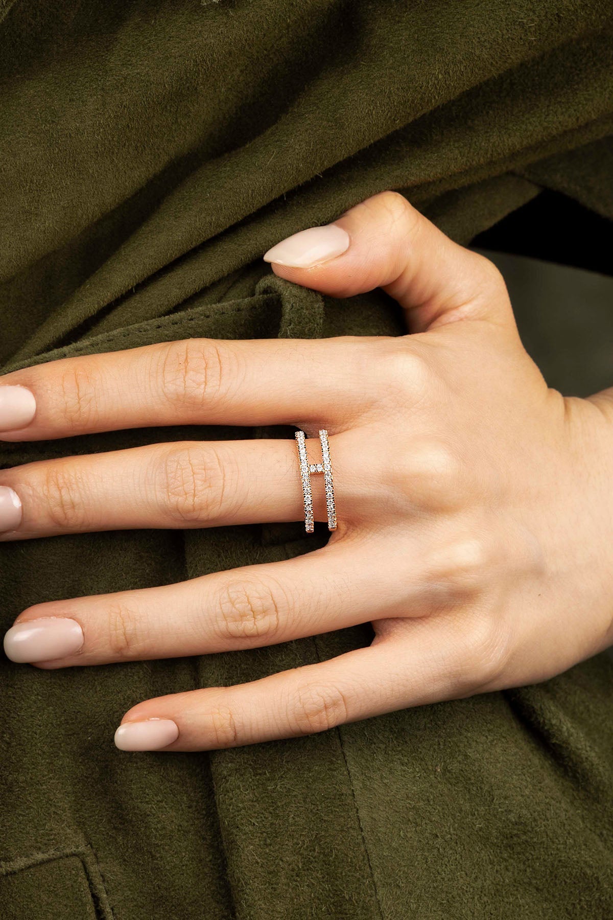 Close-up of a hand wearing a ring on a green fabric background