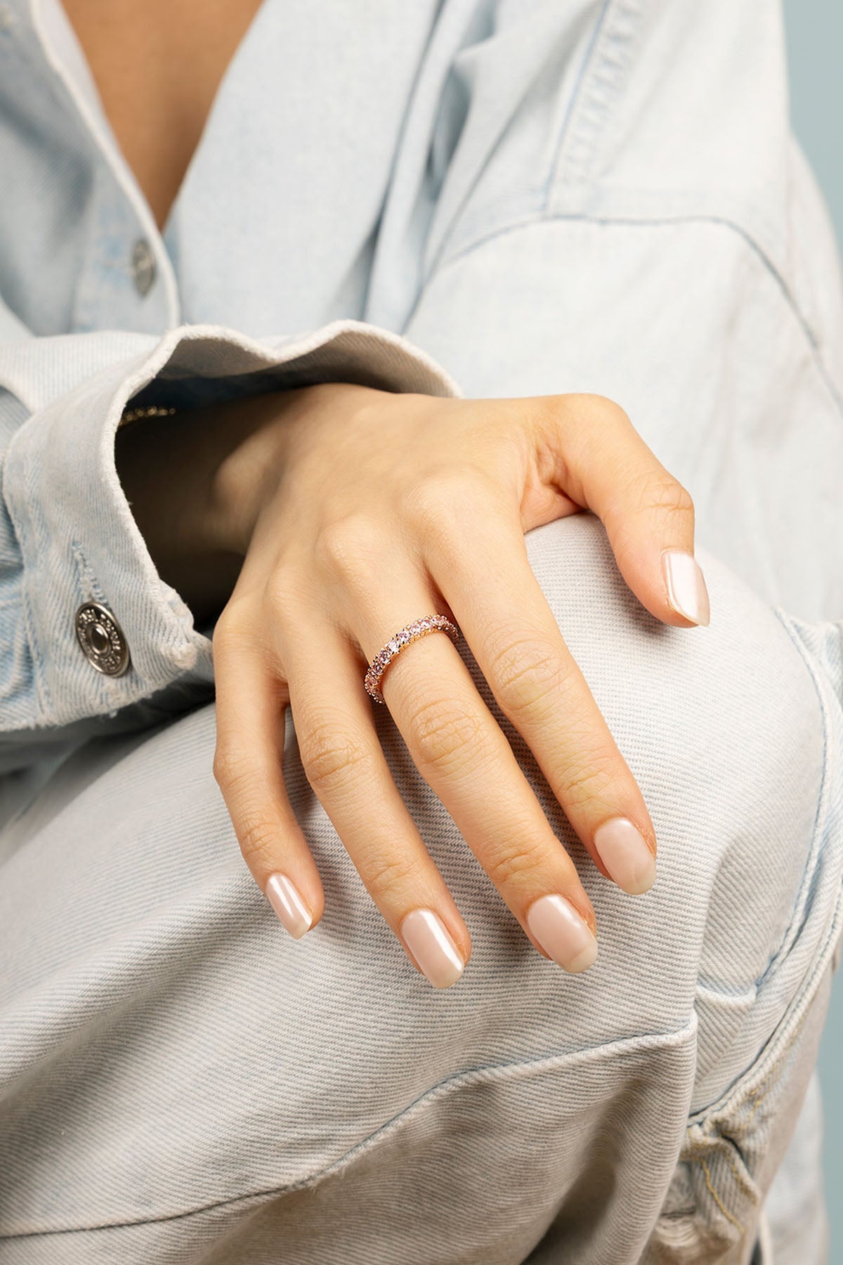 Ring, APM Monaco. Rose gold pavé ring with small crystals worn on the finger.