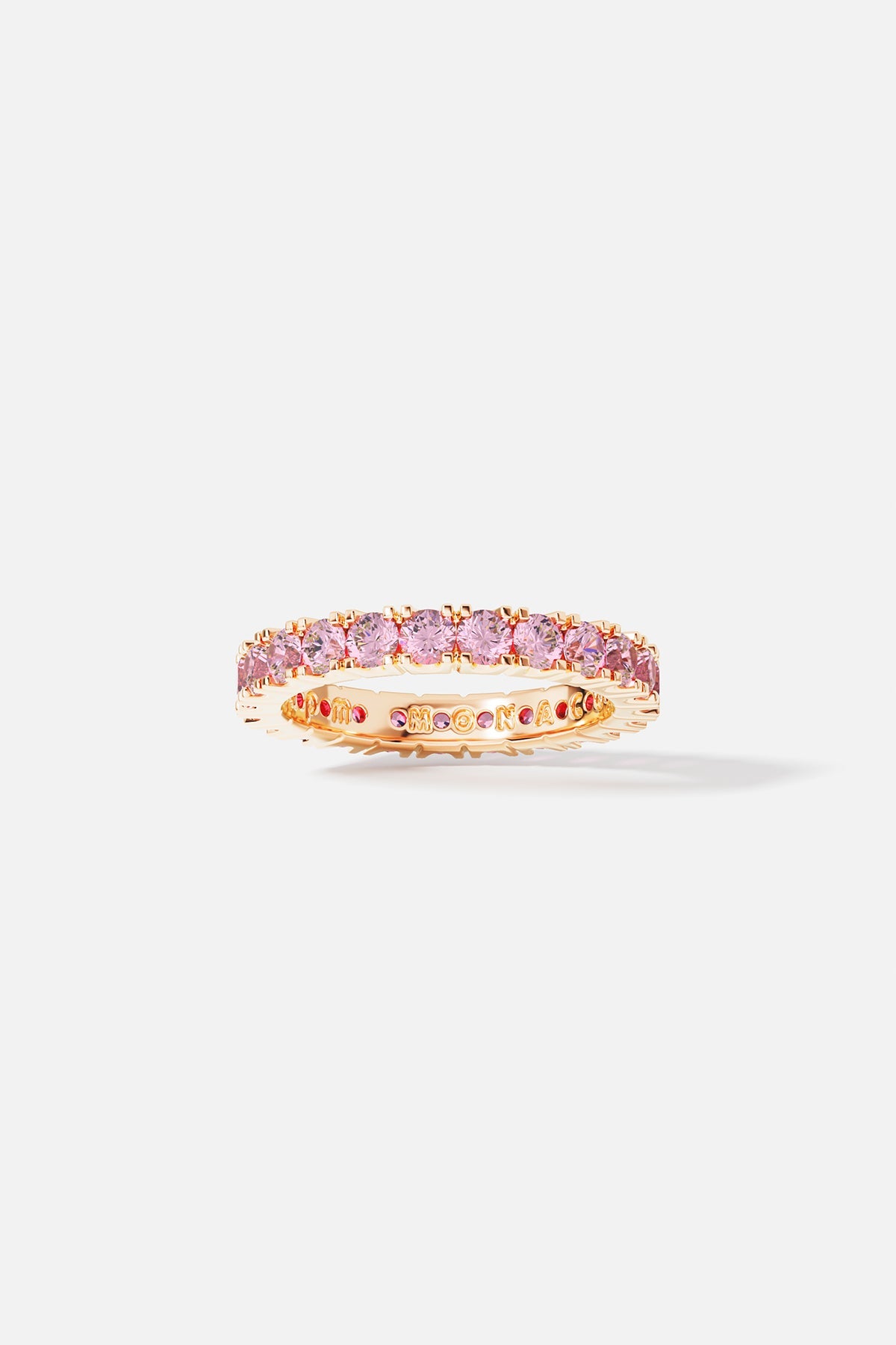 Rings APM Monaco: yellow gold pavé ring with pink stones circling the band and MOON AJ engraved on the side.