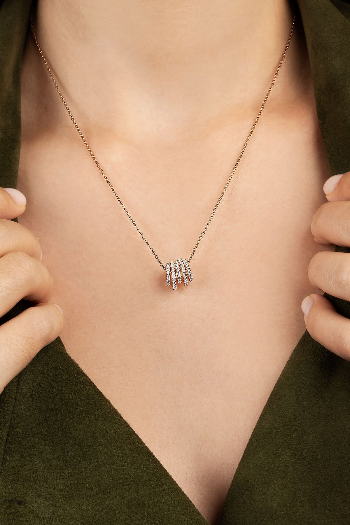 Necklace with a pendant worn by a person against a green background