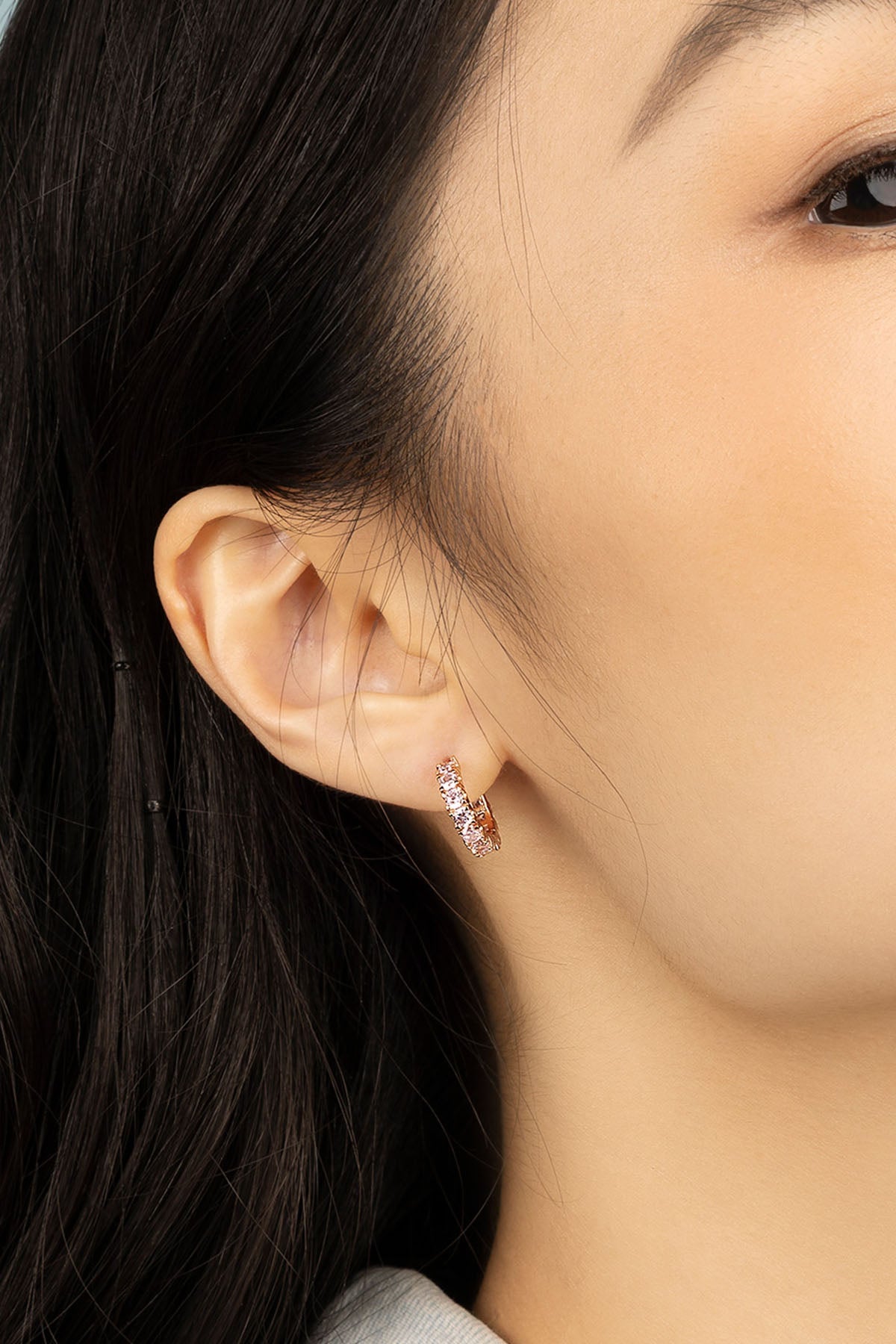 Earrings APM Monaco. Yellow gold pavé huggie hoop with pink gemstones.