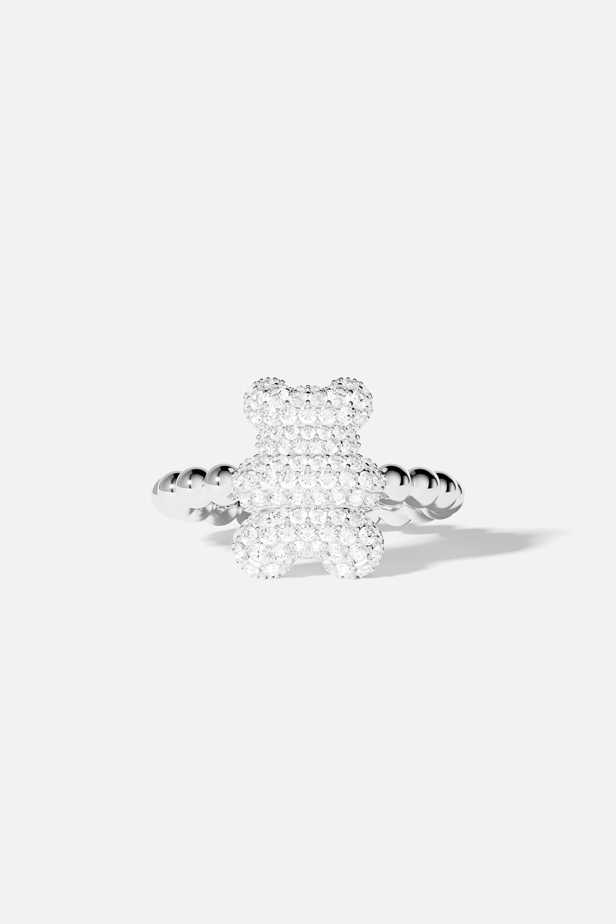 Silver teddy bear-shaped ring with clear gemstones on a white background
