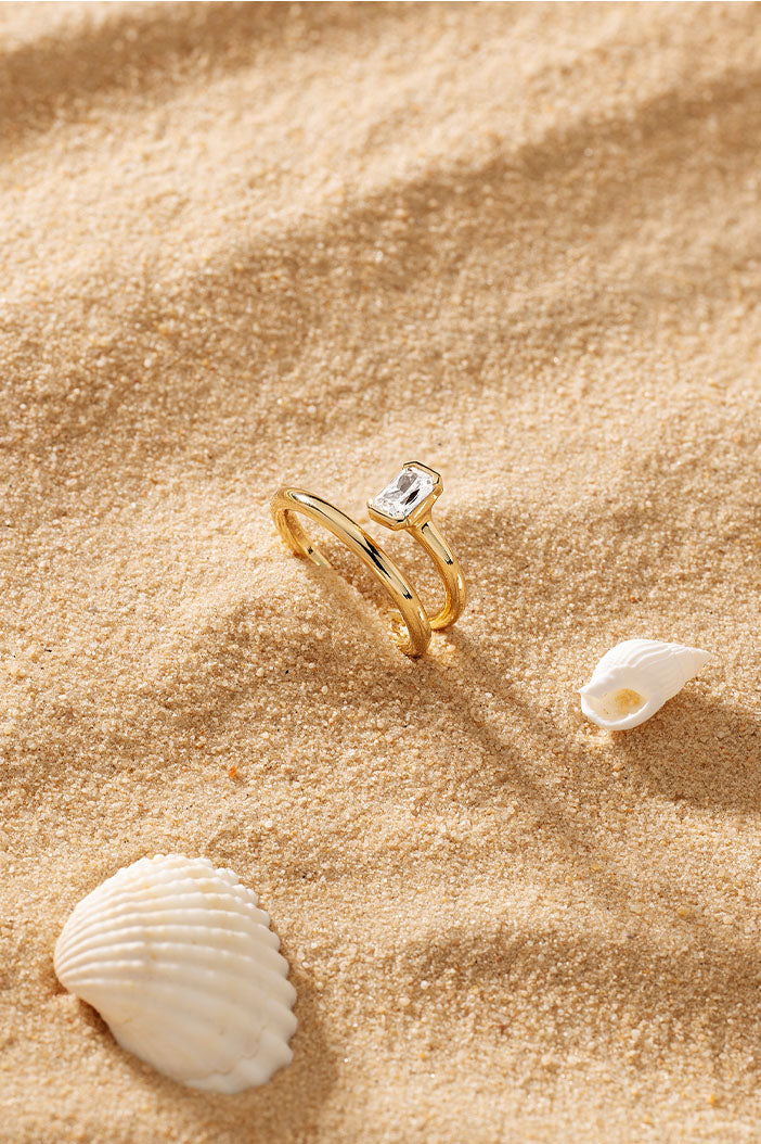 Rings APM Monaco. Yellow gold ring with a rectangular gemstone in a sand setting, twist design.