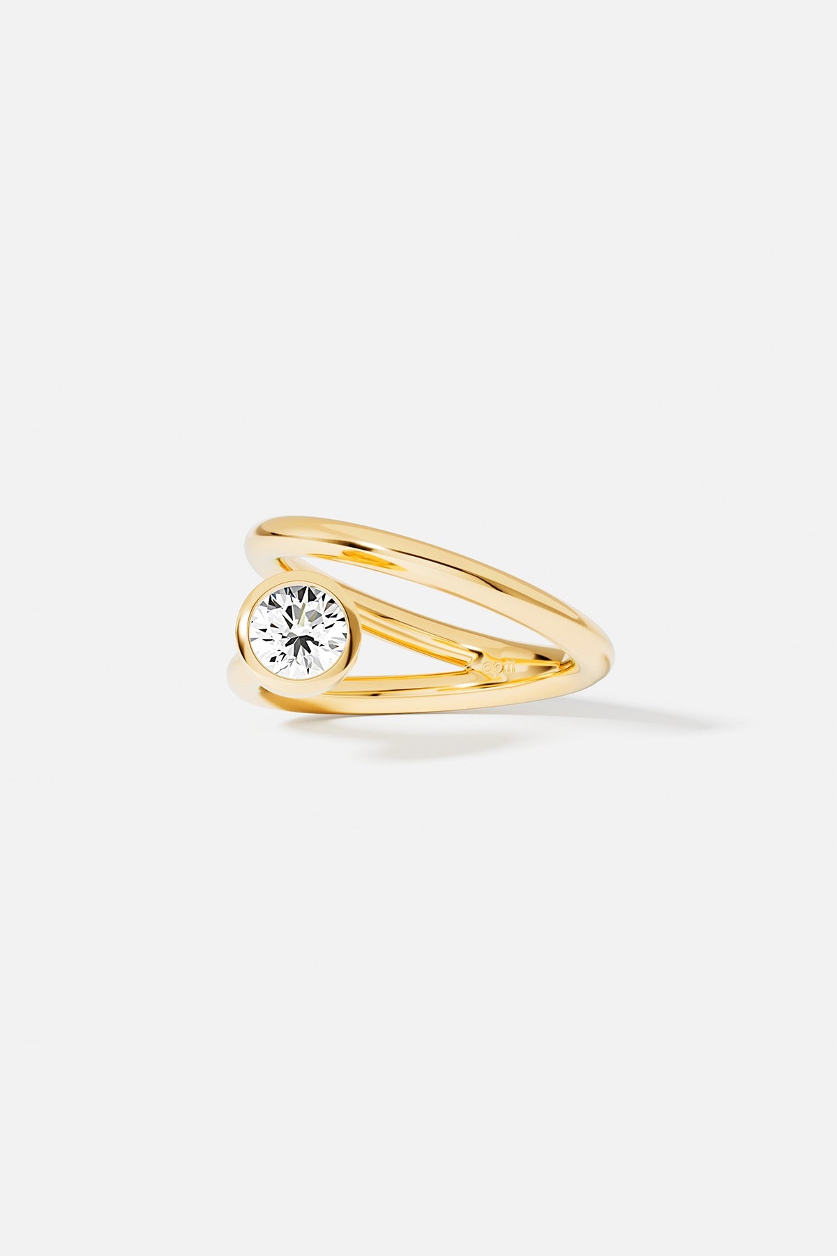 Rings APM Monaco yellow gold twist ring with a white circular stone.