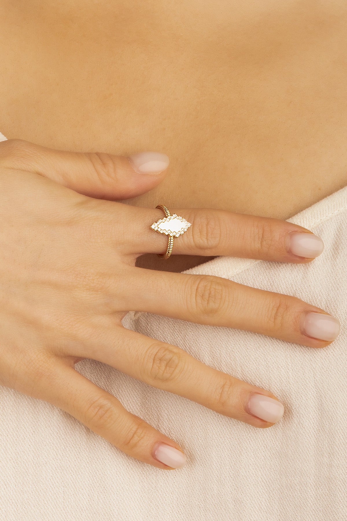 Rings APM Monaco, yellow gold ring featuring a white stone on a finger.