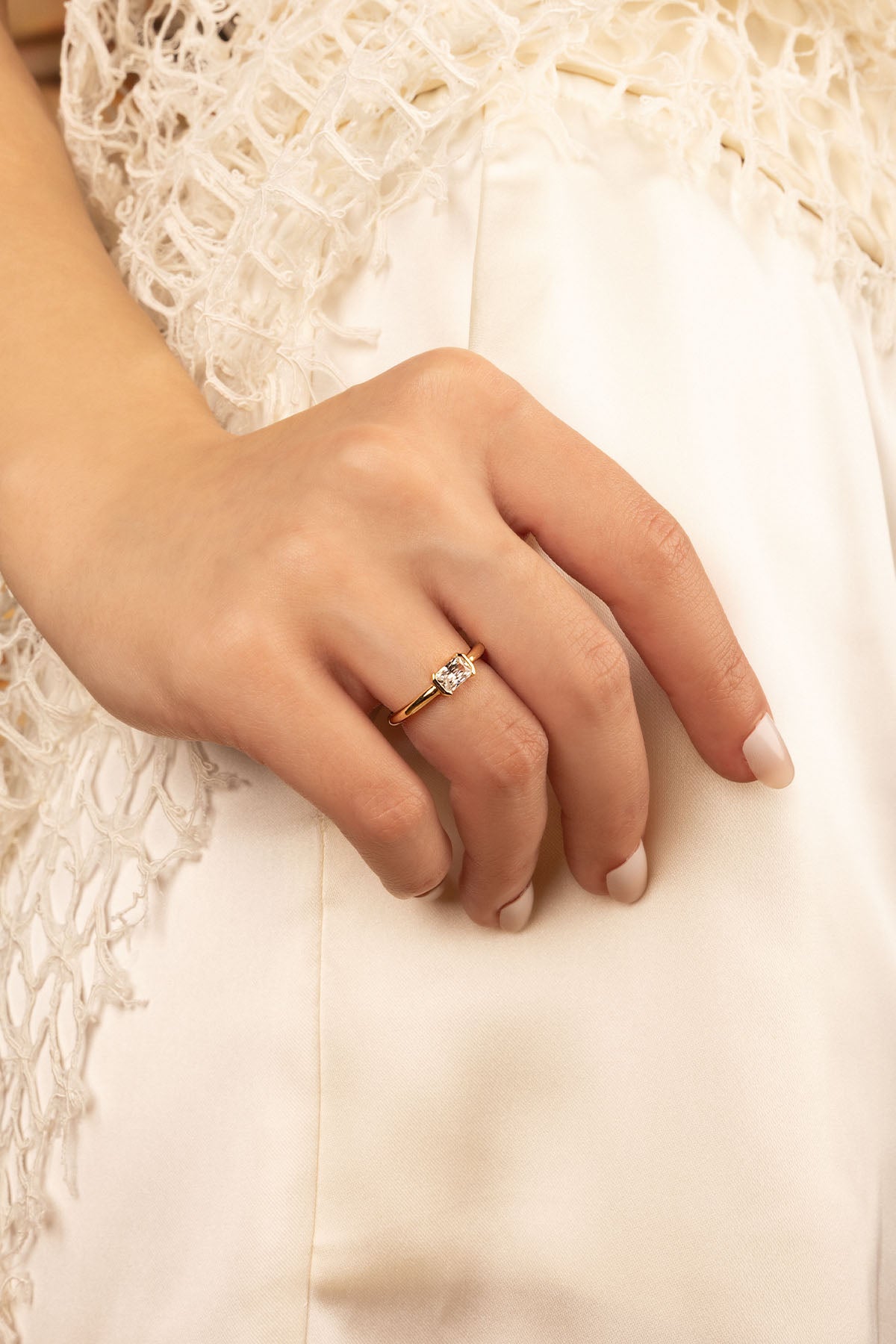 Rings APM Monaco, white metal ring with a diamond solitaire on a woman's finger.