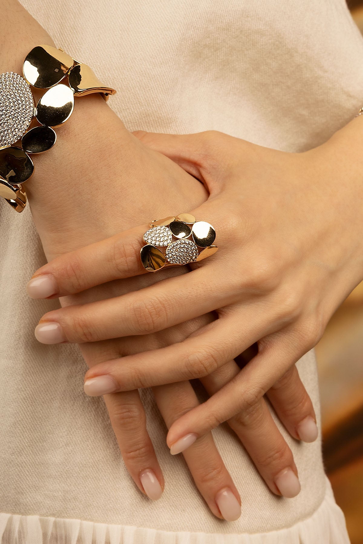 Rings, APM Monaco — Yellow gold statement galet ring with pavé diamonds on a woman's hand.