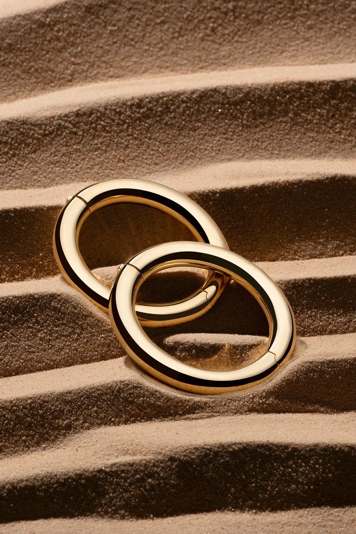 Bracelets APM Monaco, two yellow gold bold round bangles.